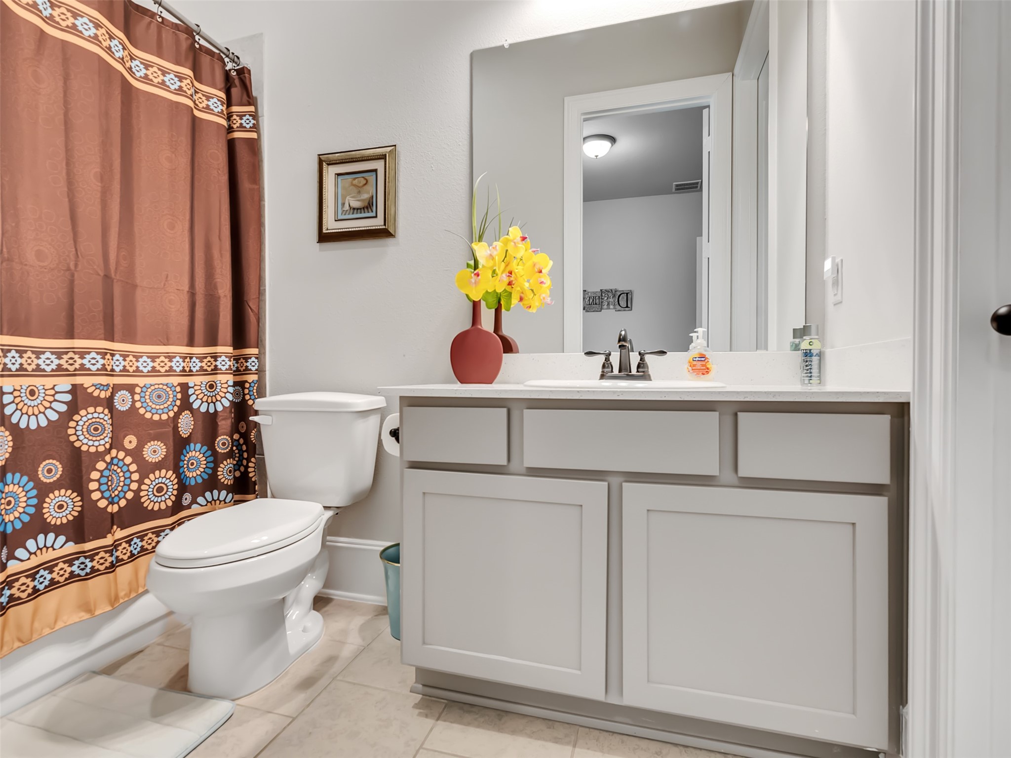 Guest bathroom with modern vanity with white cabinetry.