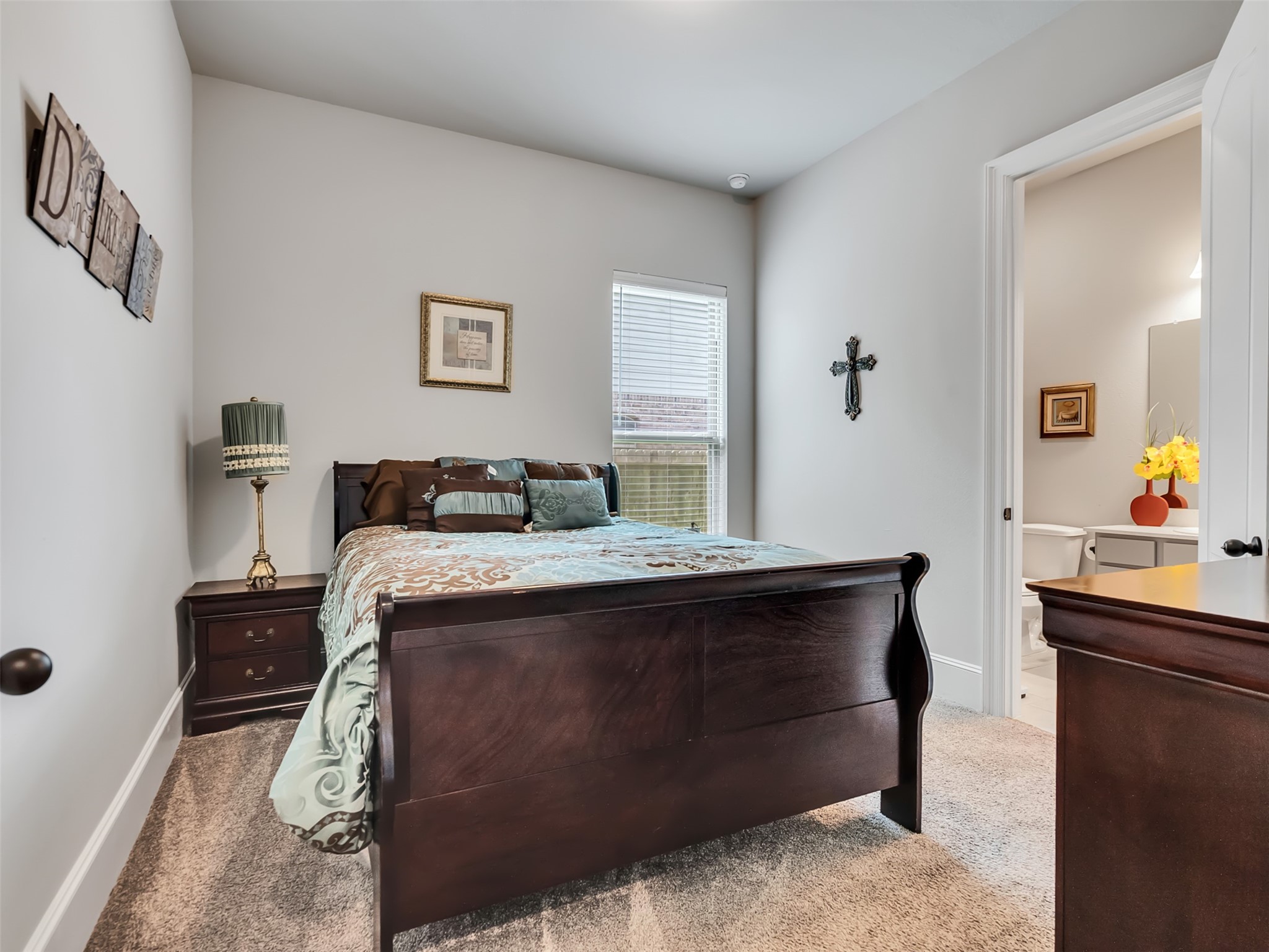 Guest bedroom located downstairs with carpet.