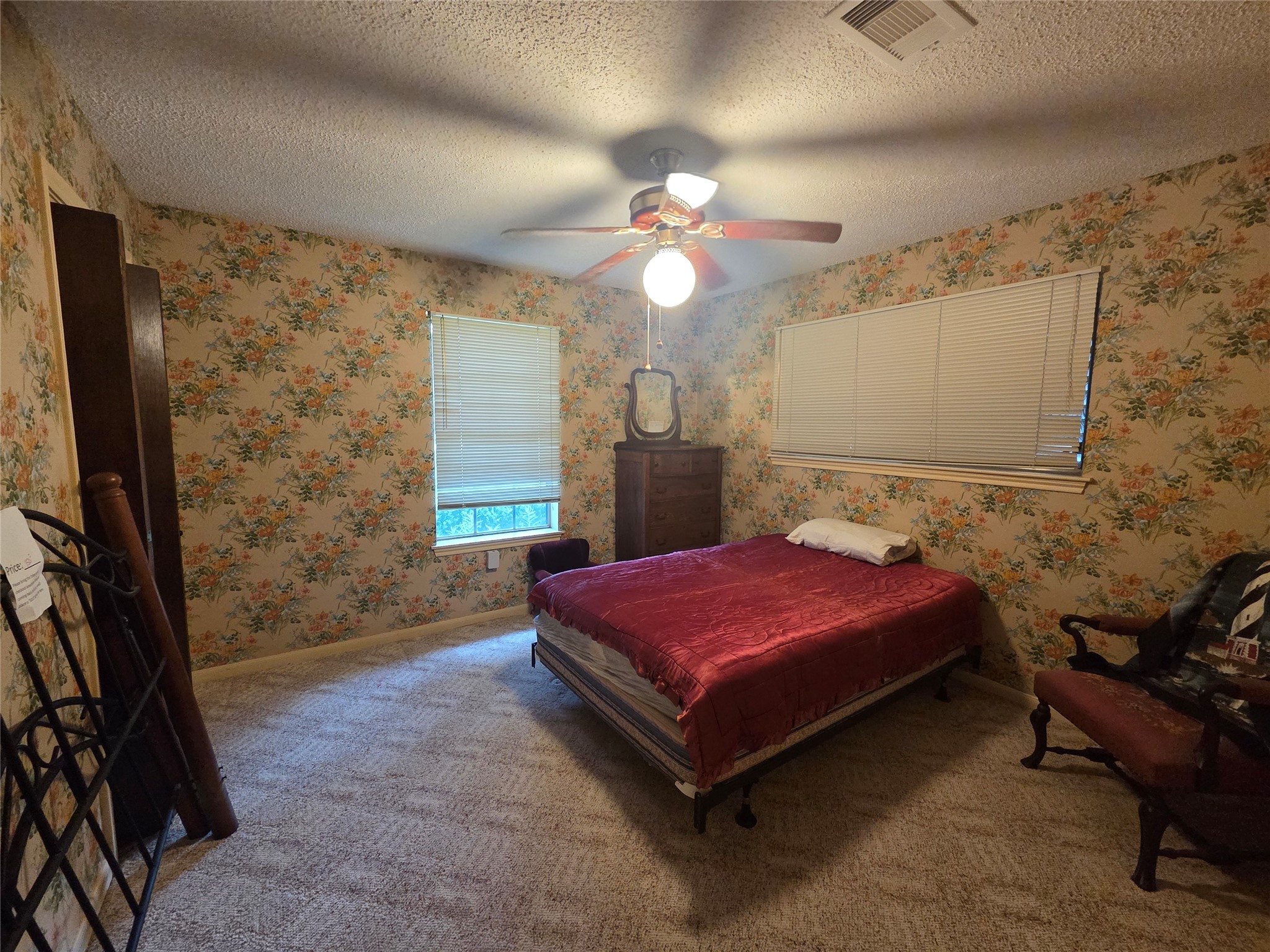 Cozy secondary bedroom with ample natural light and charming floral wallpaper.
