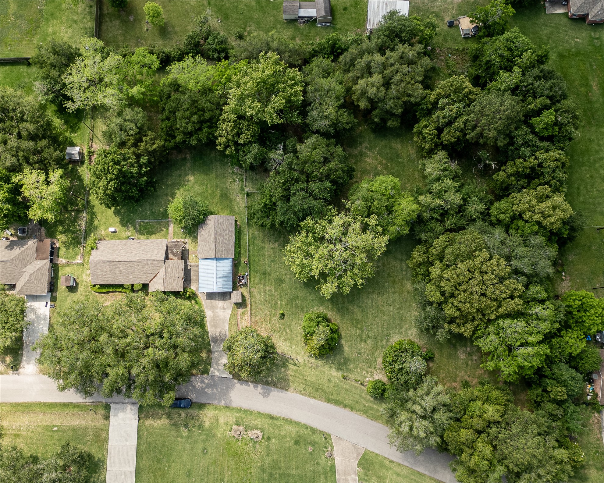 Expansive aerial view showcasing this charming home nestled in the trees, offering privacy and tranquility. Ideal for nature lovers seeking a serene retreat.