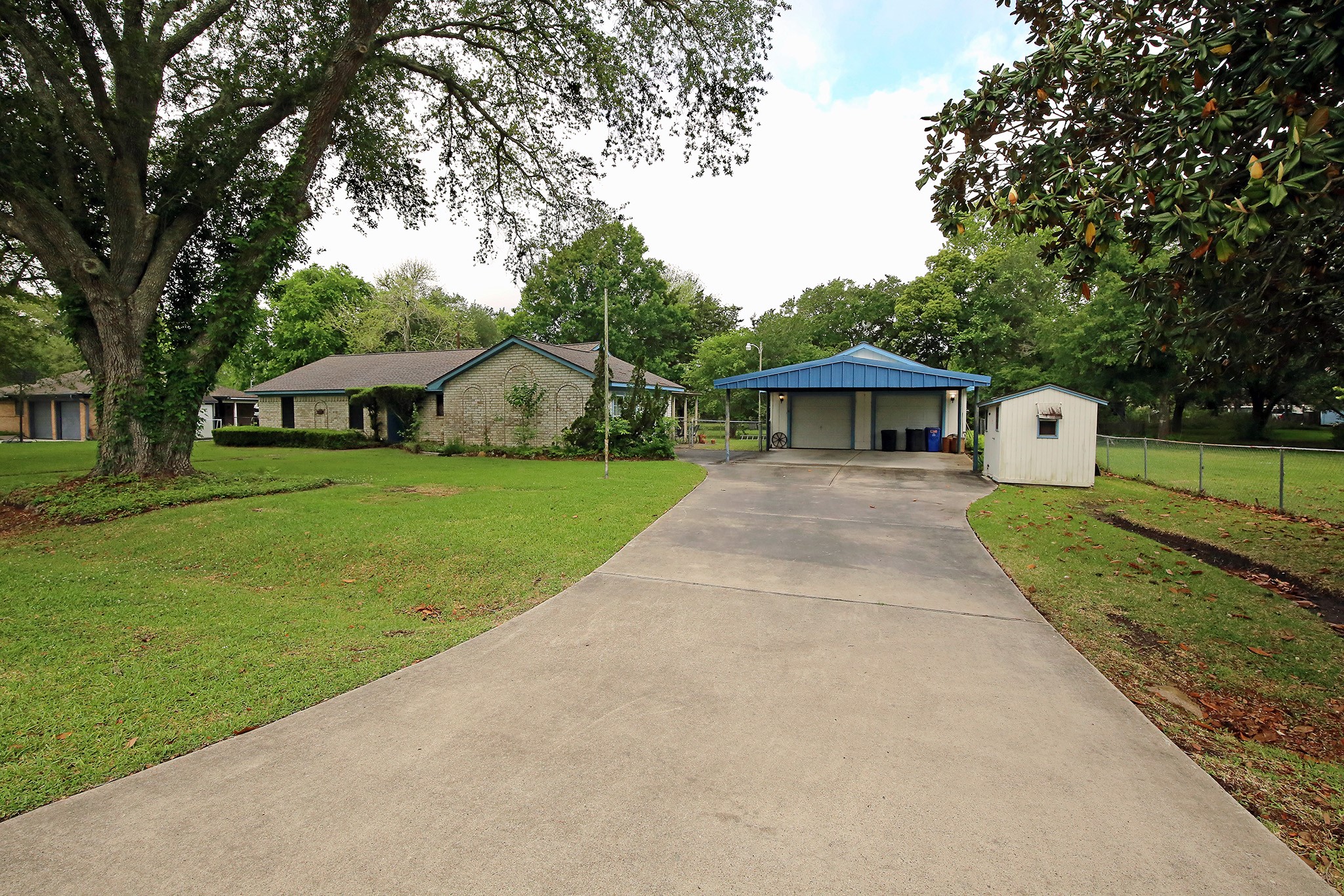 A charming single-story brick home with a carport and detached garage.