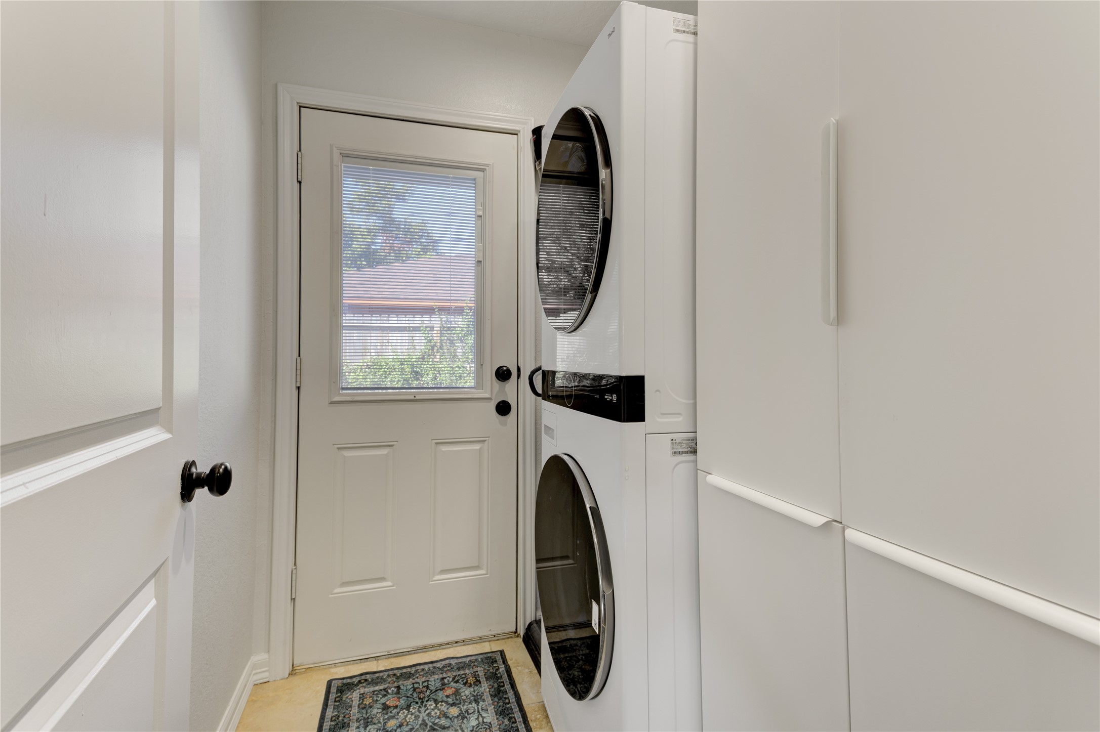 The hallway utility room offers additional storage, ample space for full-size laundry units, and access directly to the backyard.