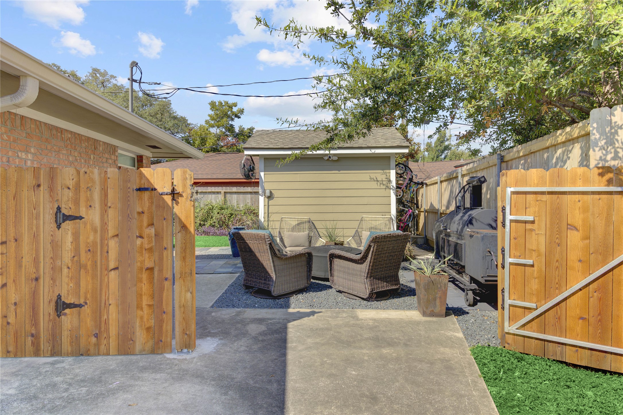 A view at the end of the driveway through the double-wide gate to the bonus backyard space.