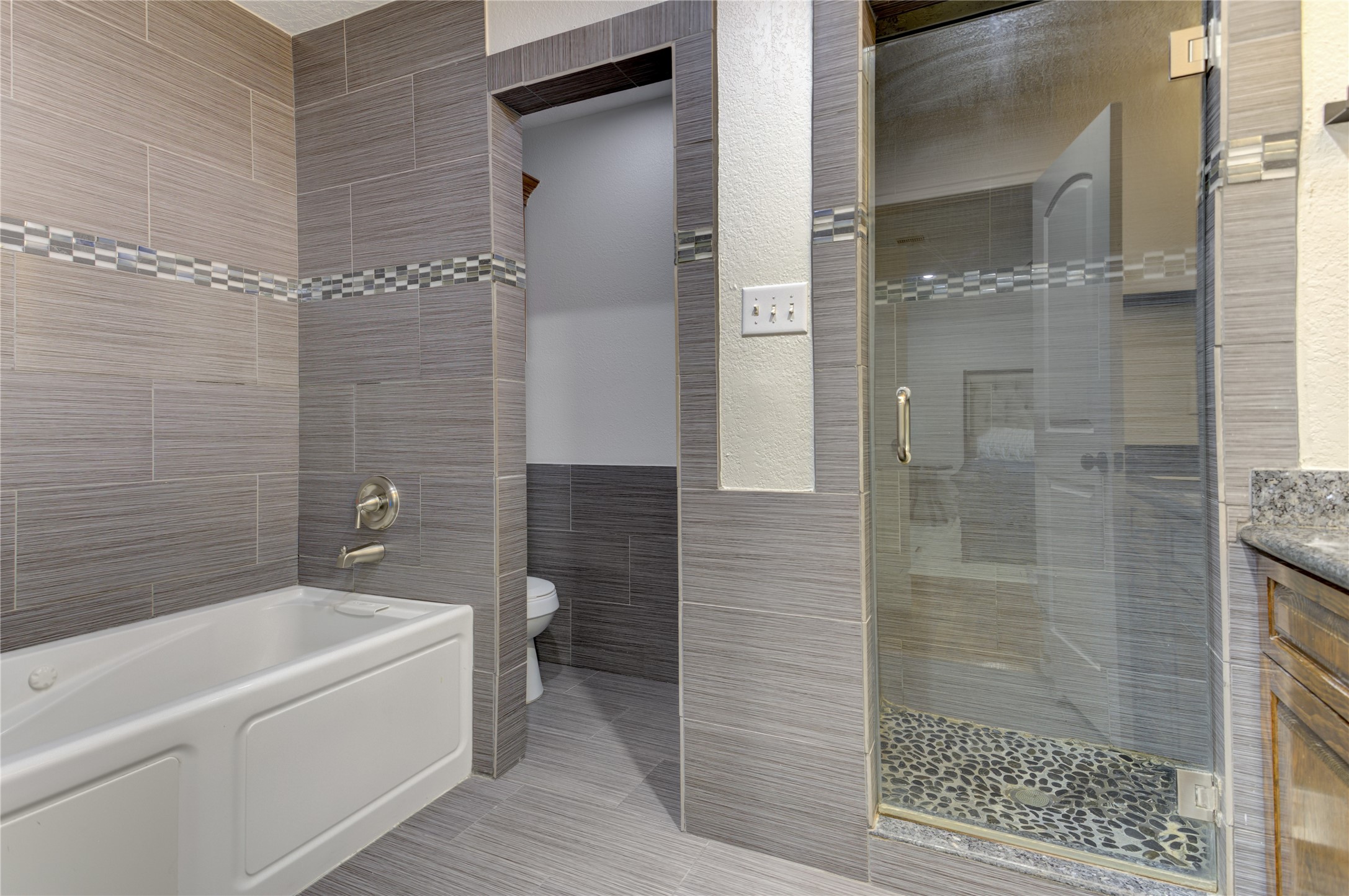 The primary bathroom offers a separate jetted tub, toilet closet, and walk-in shower with rain head and body sprays.