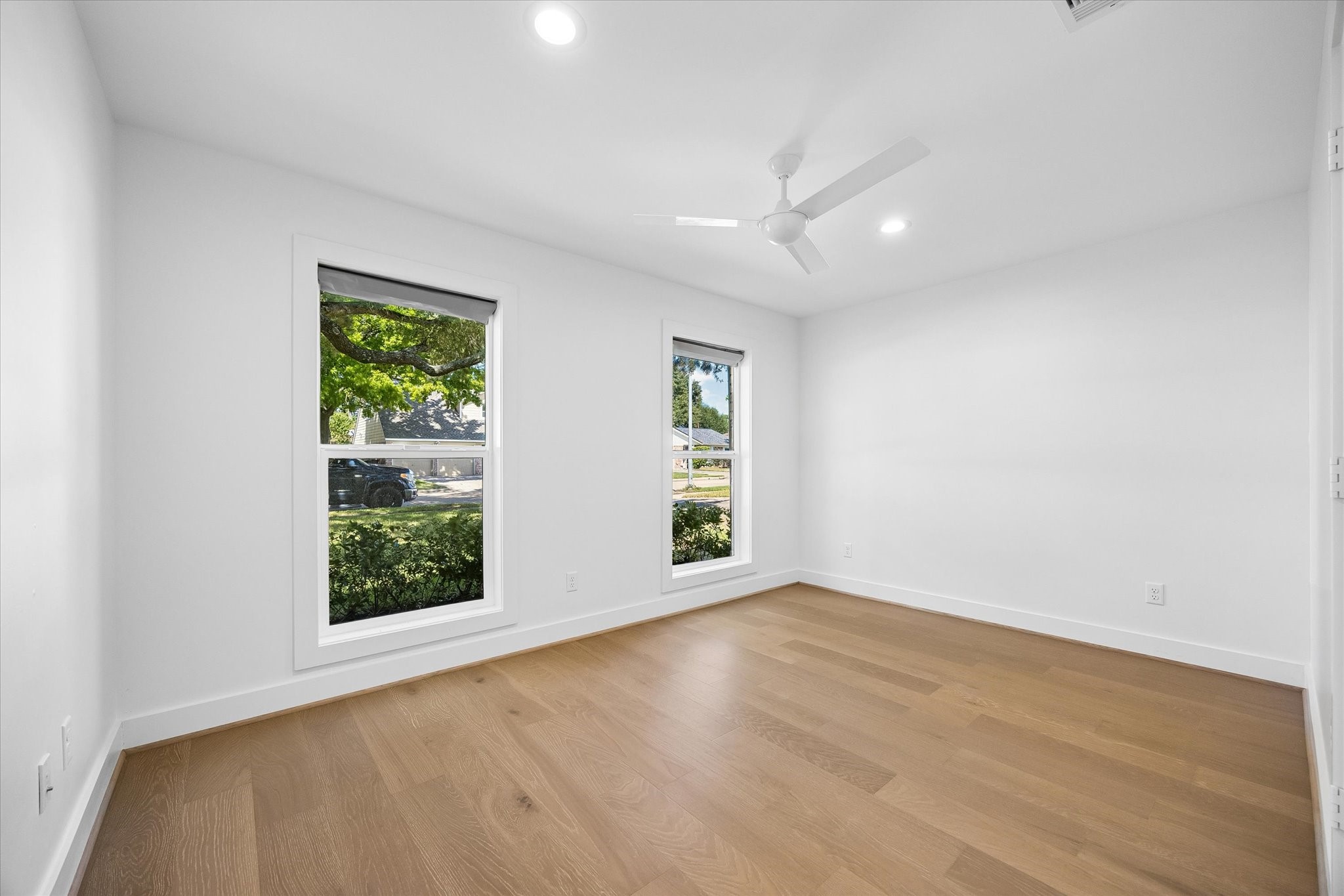 This bedroom, located at the front of the property, offers large windows that let in plenty of natural light and create an inviting look at your low maintenance front yard. Its versatile layout can accommodate various design preferences, making it a comfortable retreat for family members or guests.