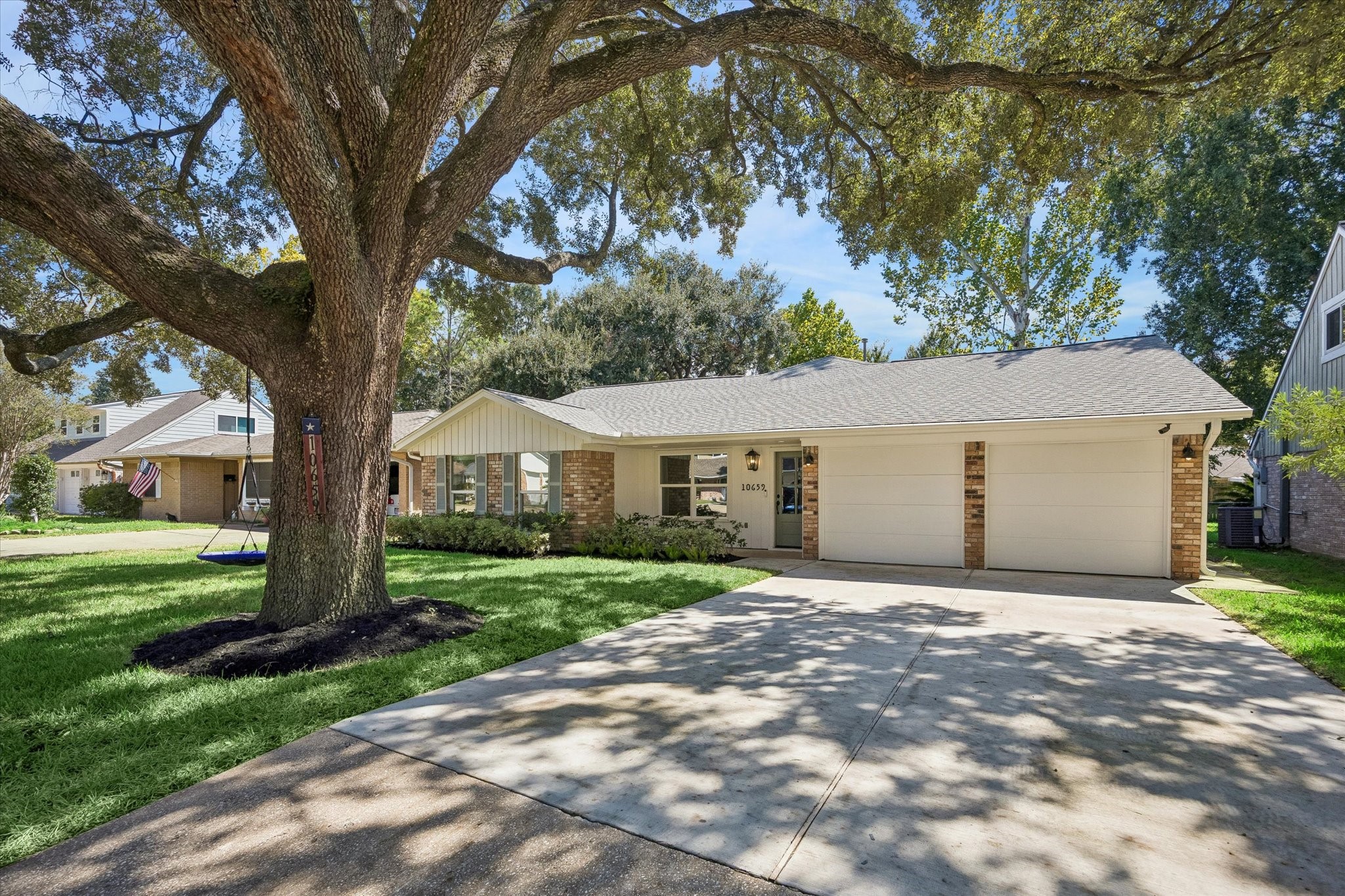 This charming property at 10659 Mayfield Road boasts a beautifully updated facade with a blend of brick and fresh white siding, complemented by a vibrant front door. The spacious front yard, shaded by a large tree, enhances the home's curb appeal. This welcoming exterior sets the tone for the inviting interior waiting to greet you.