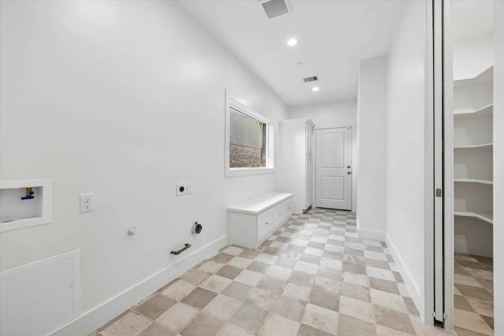 The MUD room and utility area offer practicality and organization. With ample space for full size appliances and additional storage, this room ensures convenience for daily chores. The built-in bench with drawers provides a handy spot for seating and stowing away shoes or other items, enhancing the room's functionality.