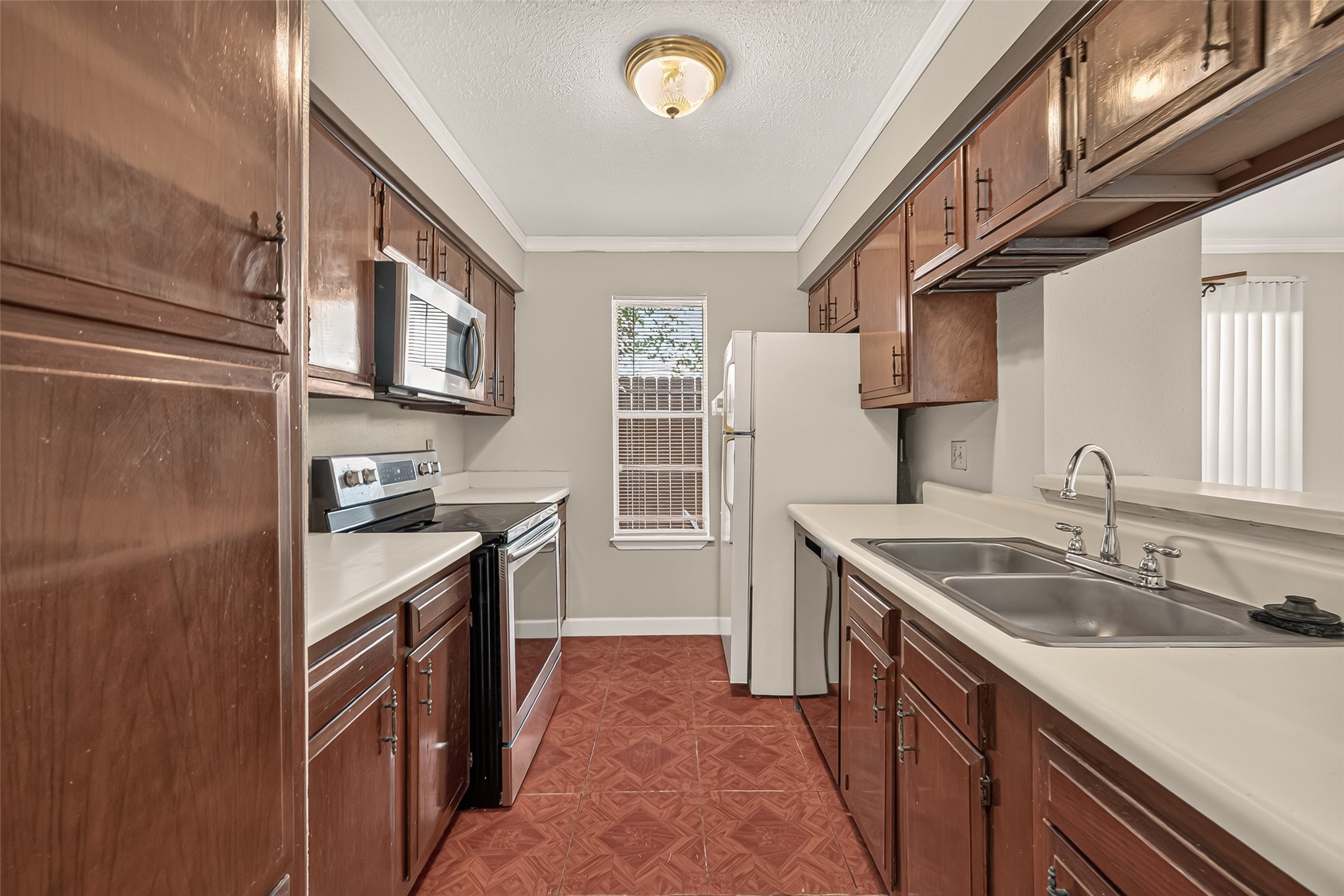 Charming kitchen features rich wood cabinetry and a cozy window allowing natural light to brighten the space.