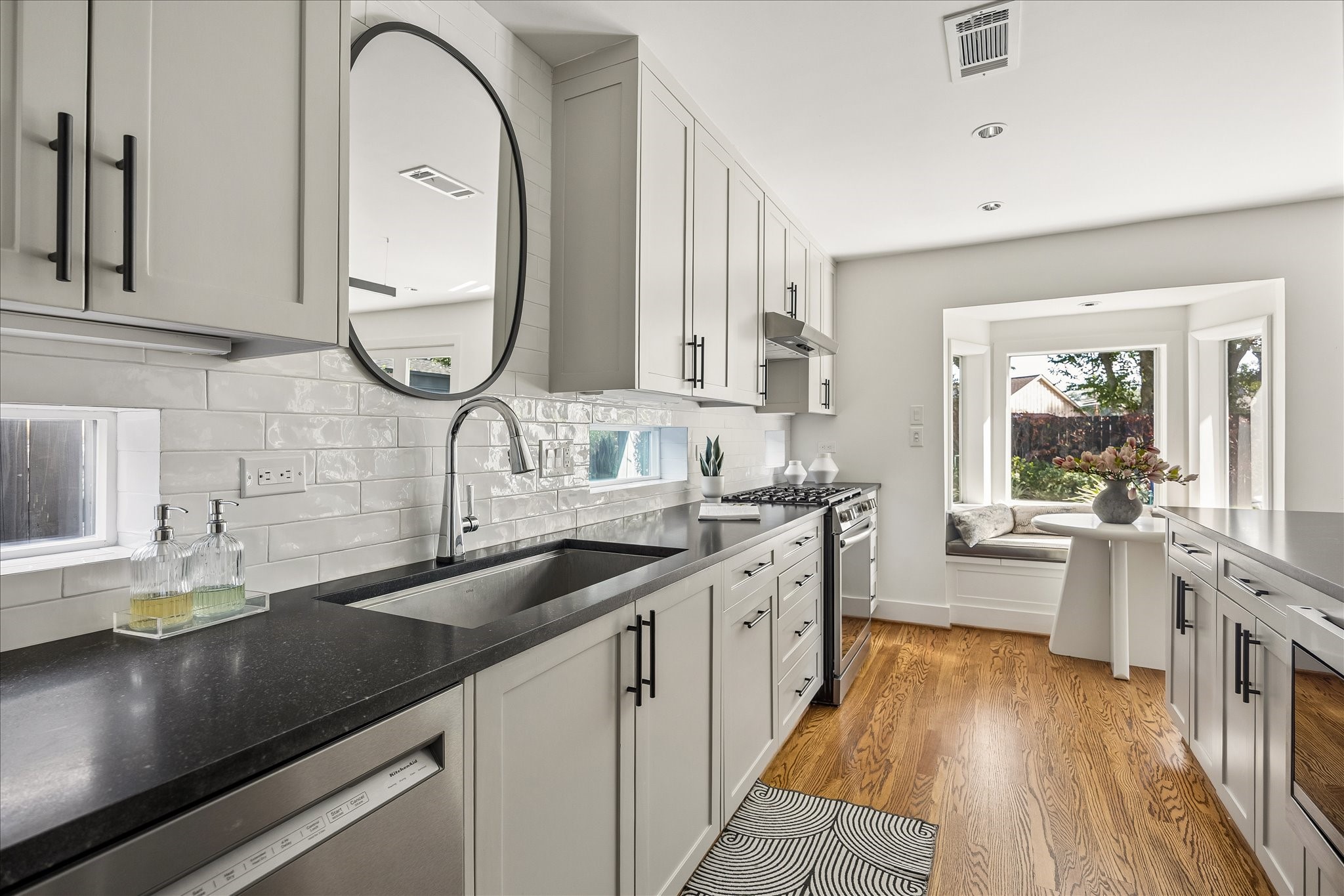 A sleek undermount sink, slim horizontal windows, and classic subway tile lend a clean, tailored finish to the kitchen.