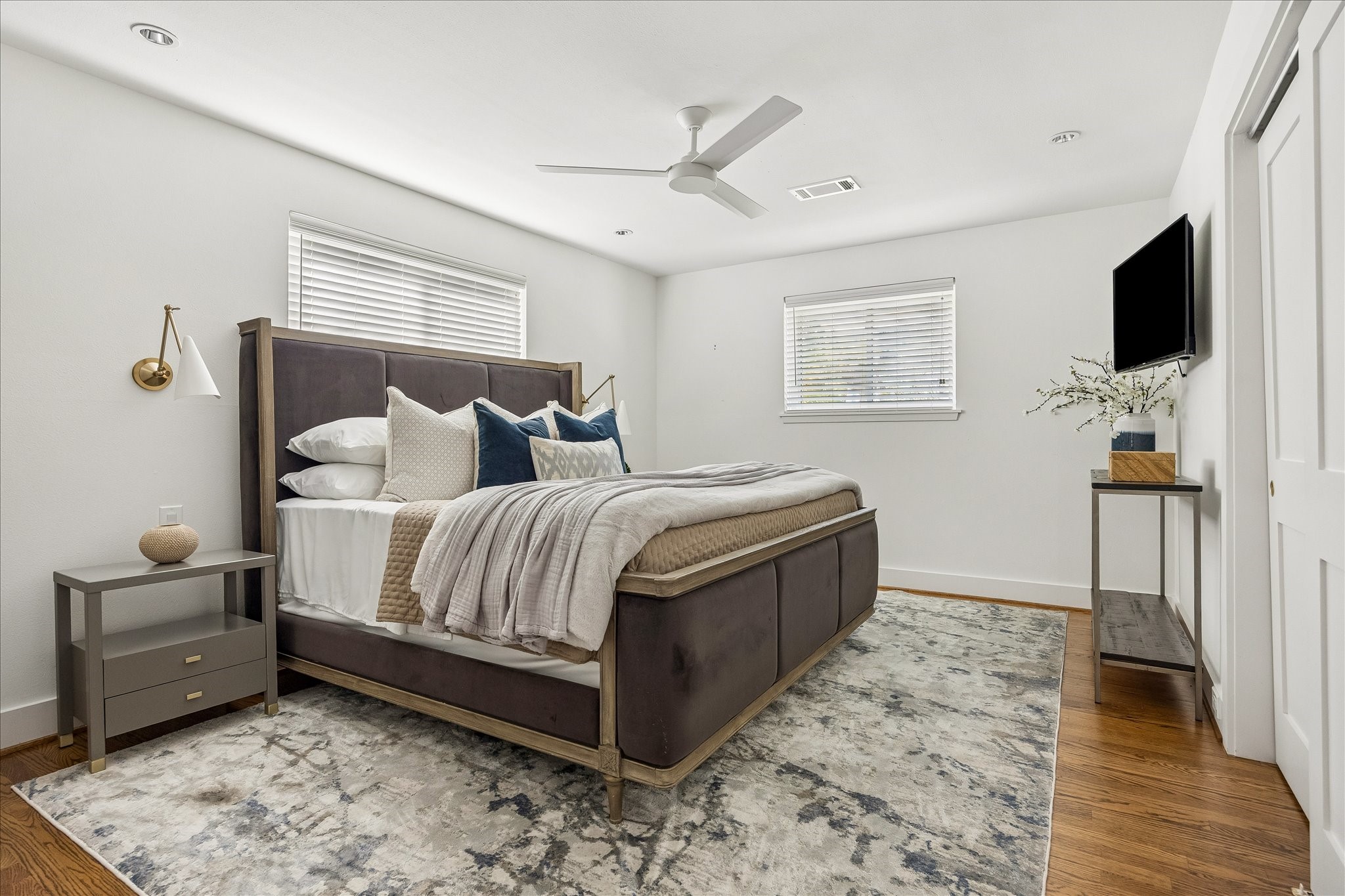 Soft natural light, warm hardwood flooring, and a calming neutral palette create a restful primary retreat.