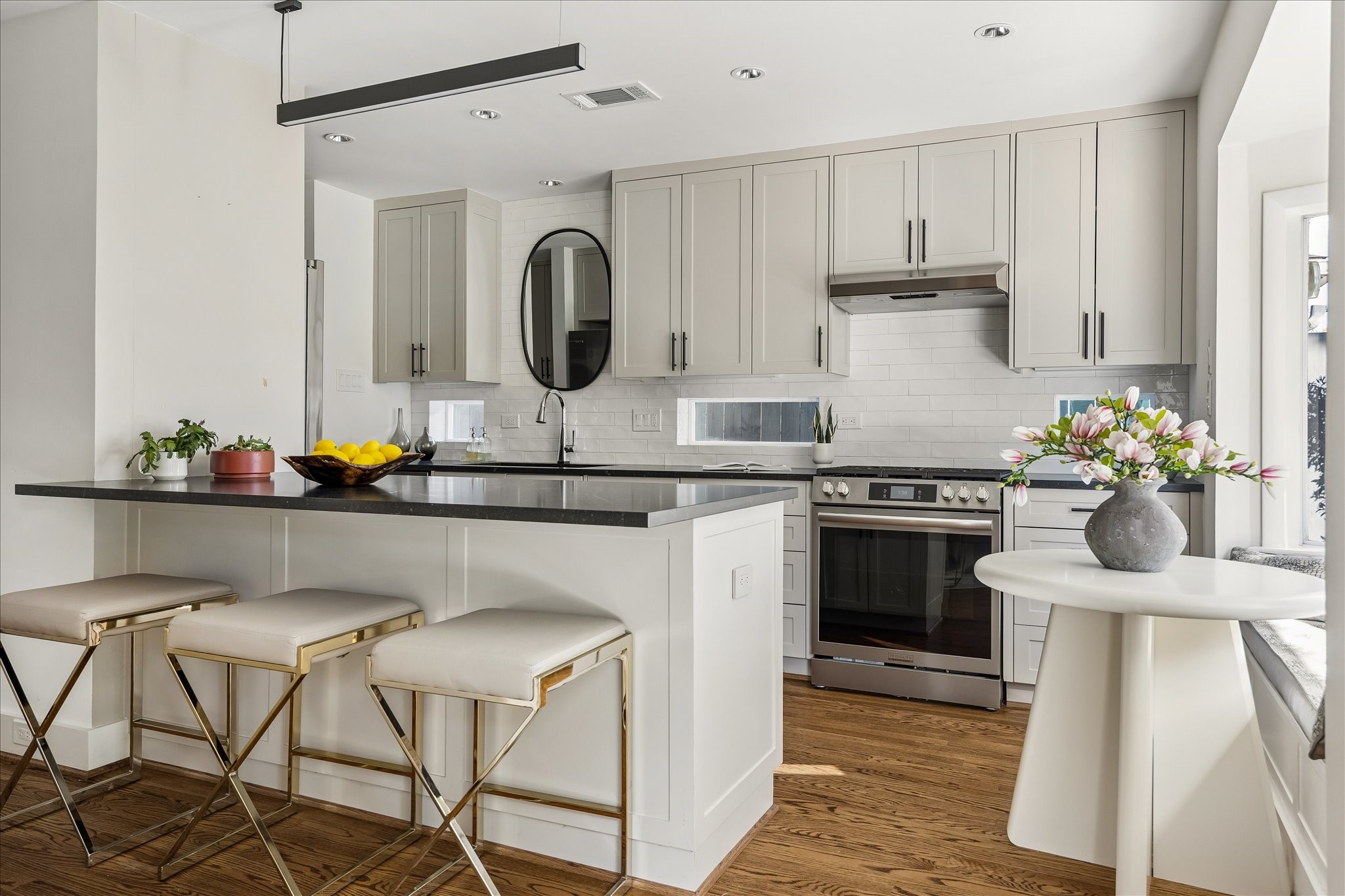 A cheerful breakfast nook with banquette seating complements the kitchen's generous breakfast bar, creating inviting spaces for casual dining.