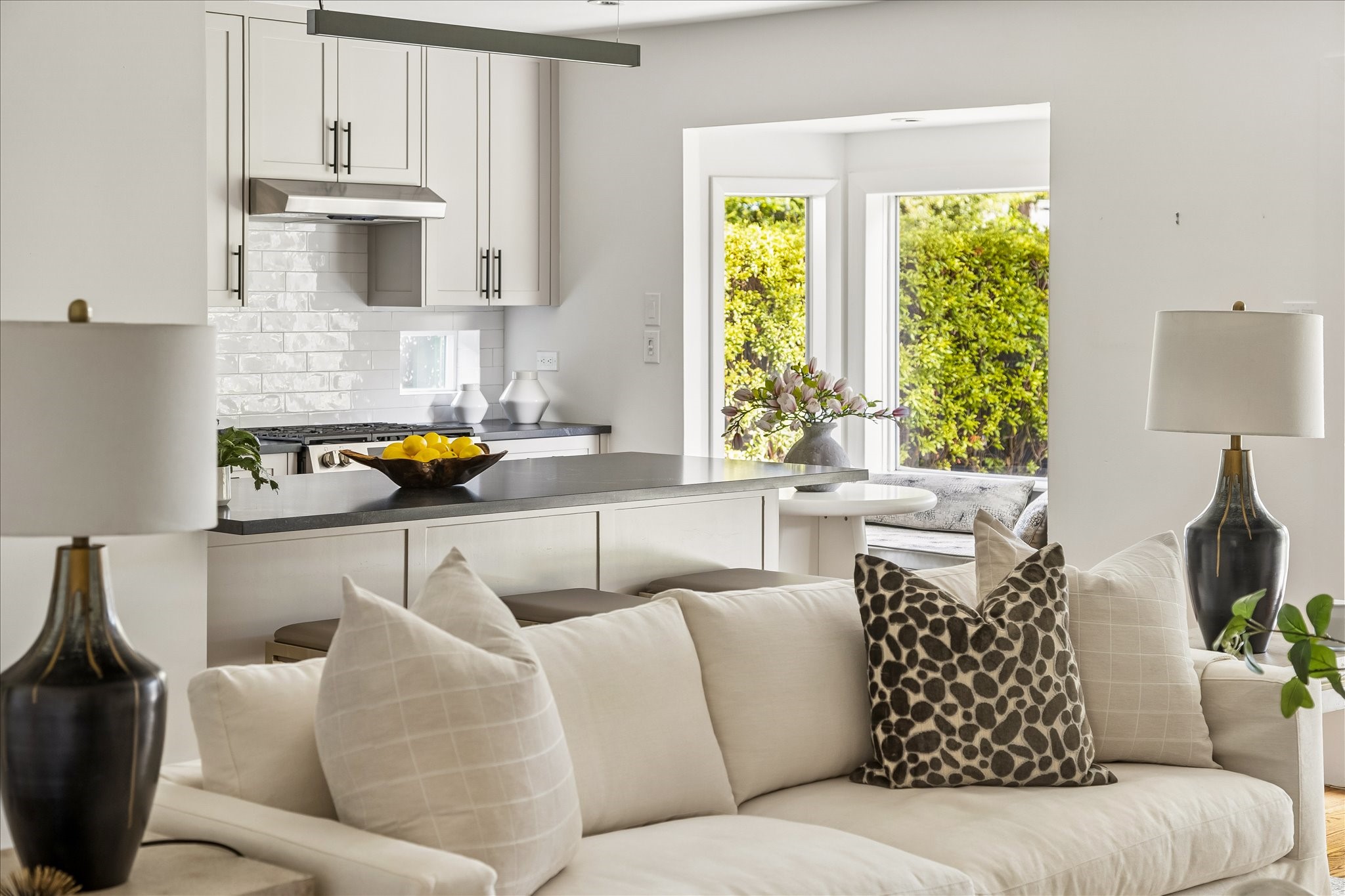 A lovely perspective toward the kitchen and sunlit breakfast nook highlights the home's effortless, connected layout.