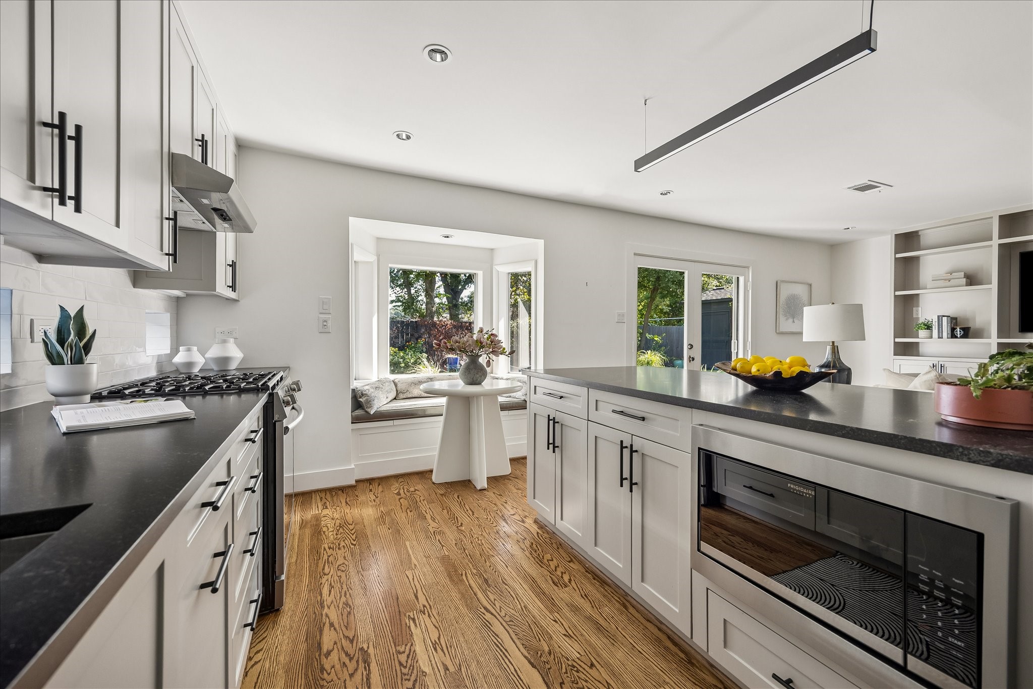 A generous peninsula with built-in microwave and breakfast bar seating connects the kitchen to the adjoining family room and charming breakfast nook.