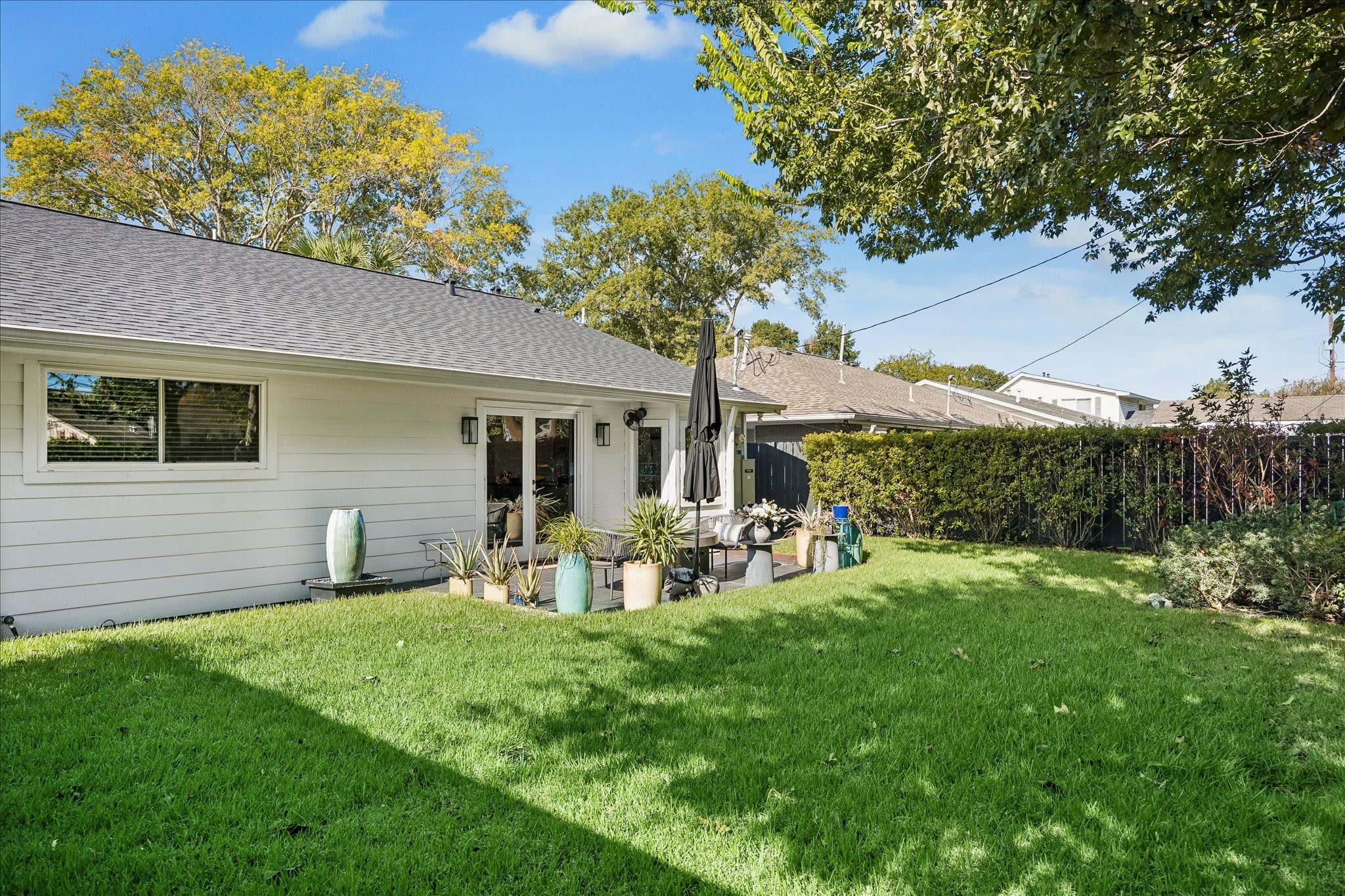 A generous stretch of green lawn and established perimeter landscaping create a lovely setting for outdoor enjoyment.