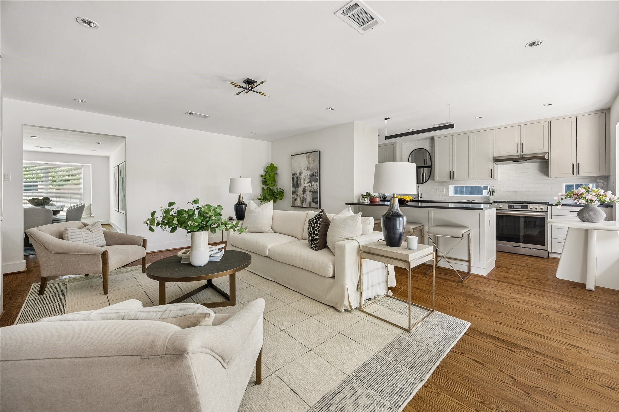 An airy, light-filled family room flows effortlessly into the kitchen, with rich hardwood floors bringing warmth throughout.