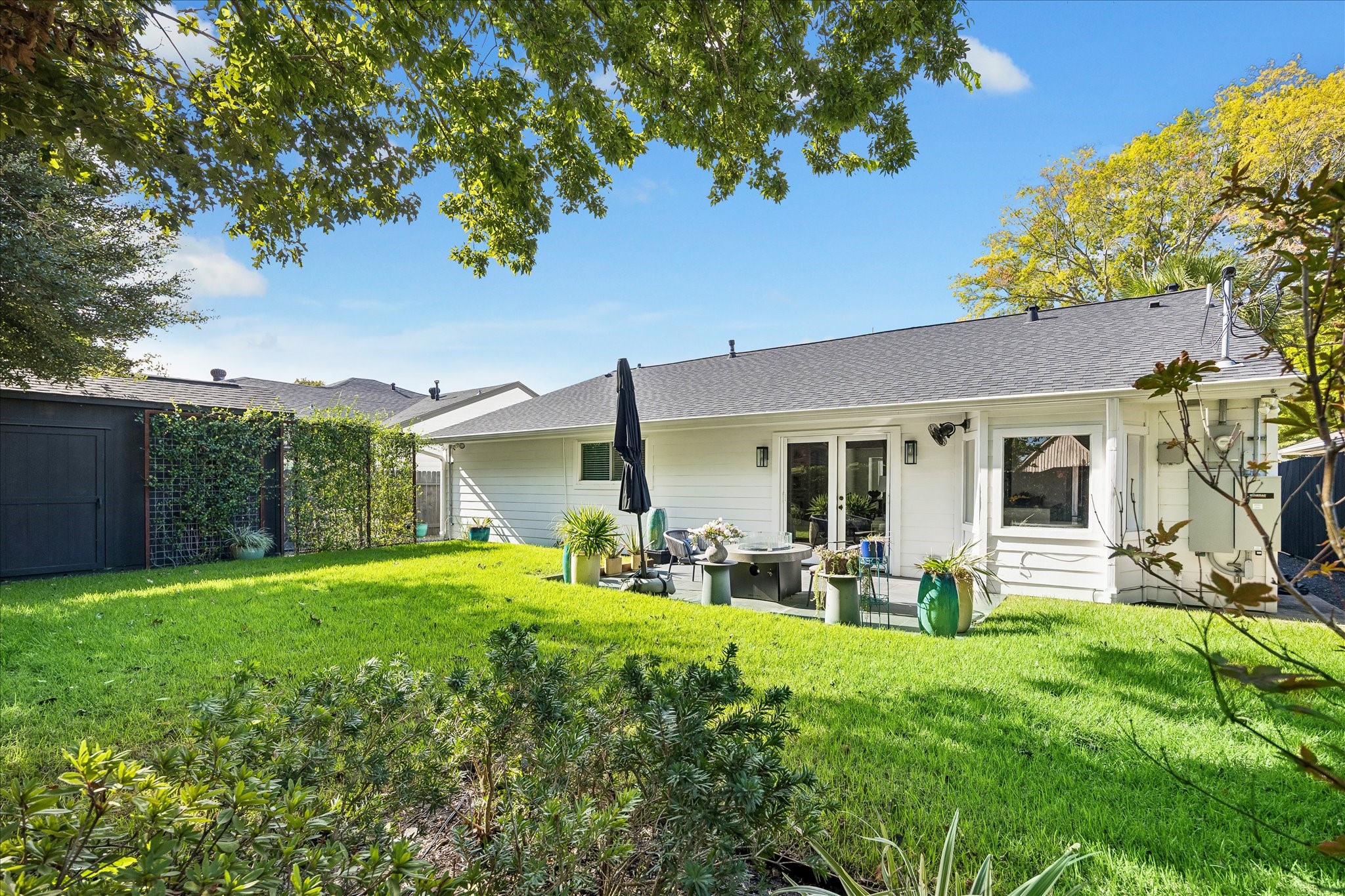 Layered greenery and beautifully maintained grounds offer a picturesque view of the home's rear elevation.