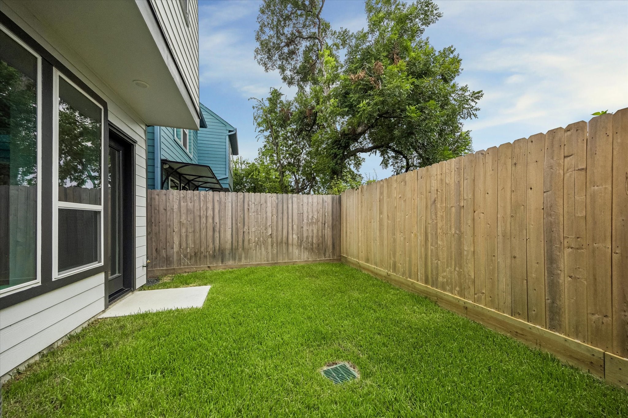 Charming fenced backyard with lush green lawn, perfect for privacy and relaxation.