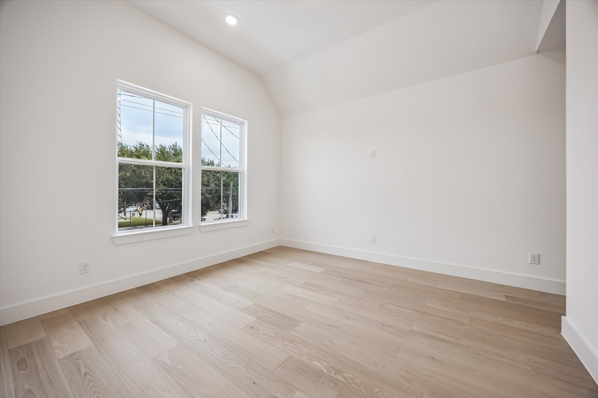 Bright and airy room featuring large windows, hardwood floors, and high ceilings, perfect for a cozy retreat or versatile workspace.