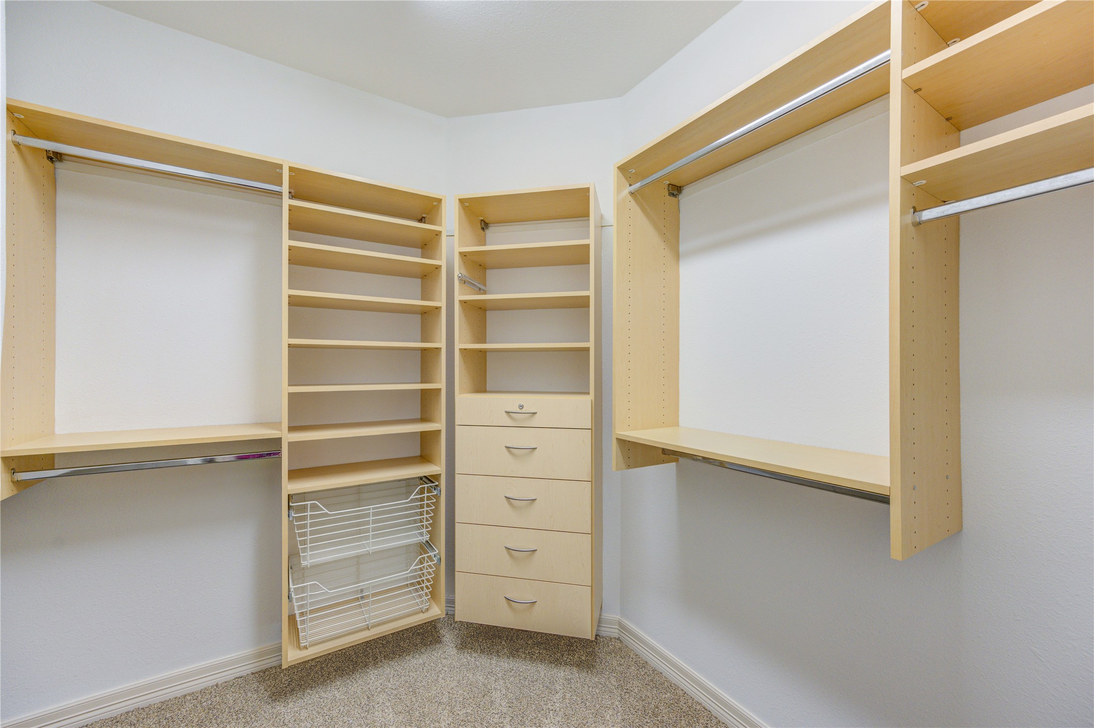 Spacious primary closet thoughtfully designed with separate sections for her and him, offering ample shelving and organized storage throughout