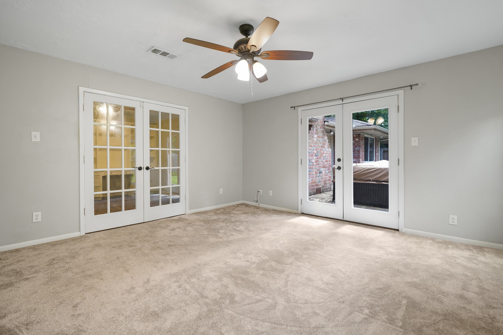 Two sets of French Doors- one leads to the back yard, the other leads to the flex space in this primary suite.