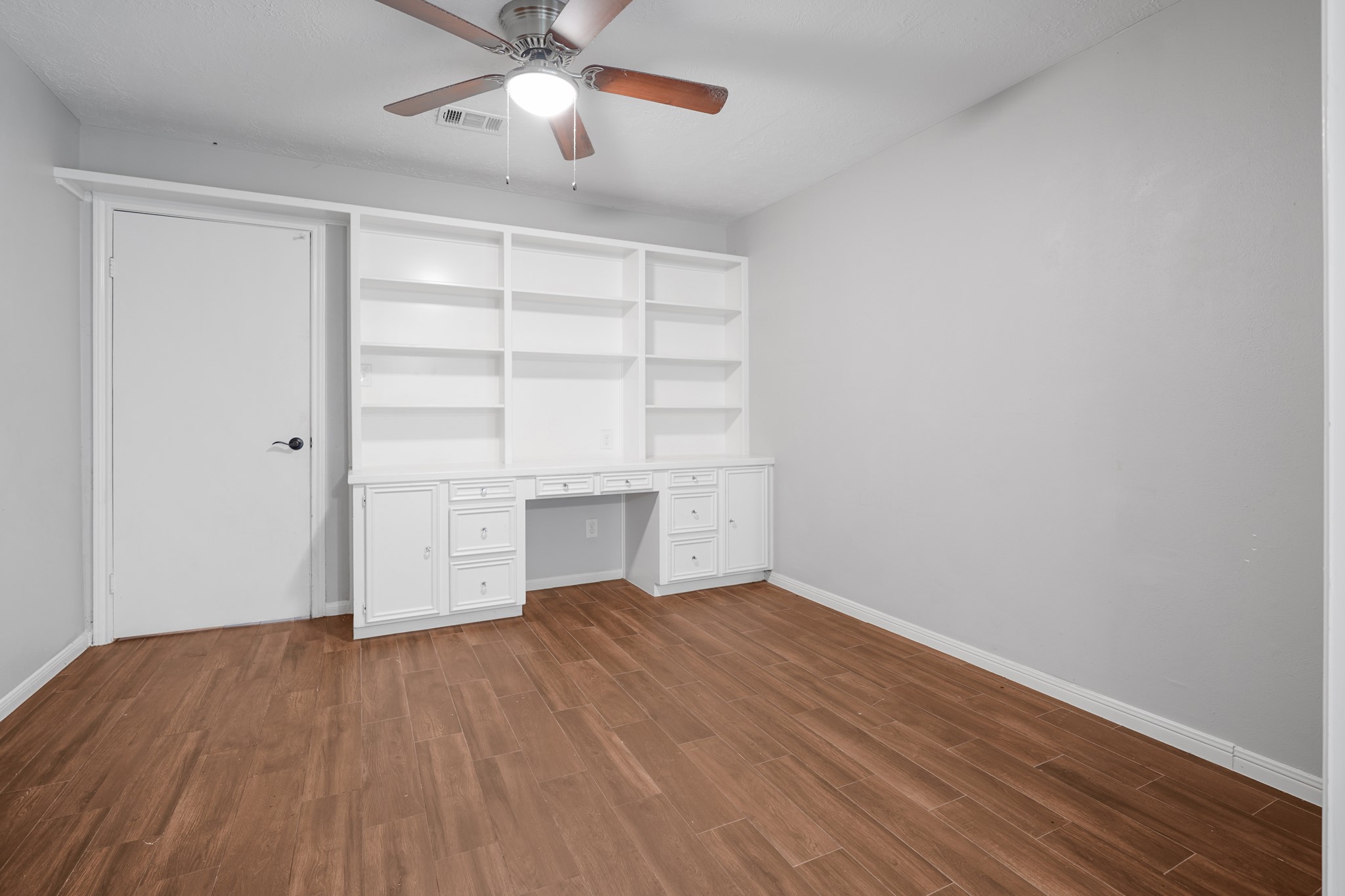 The other primary bedroom on the main level. This is a great flex area that could be used as a vanity, gym, nursery or office. It has French doors that close off the other half of this primary suite.