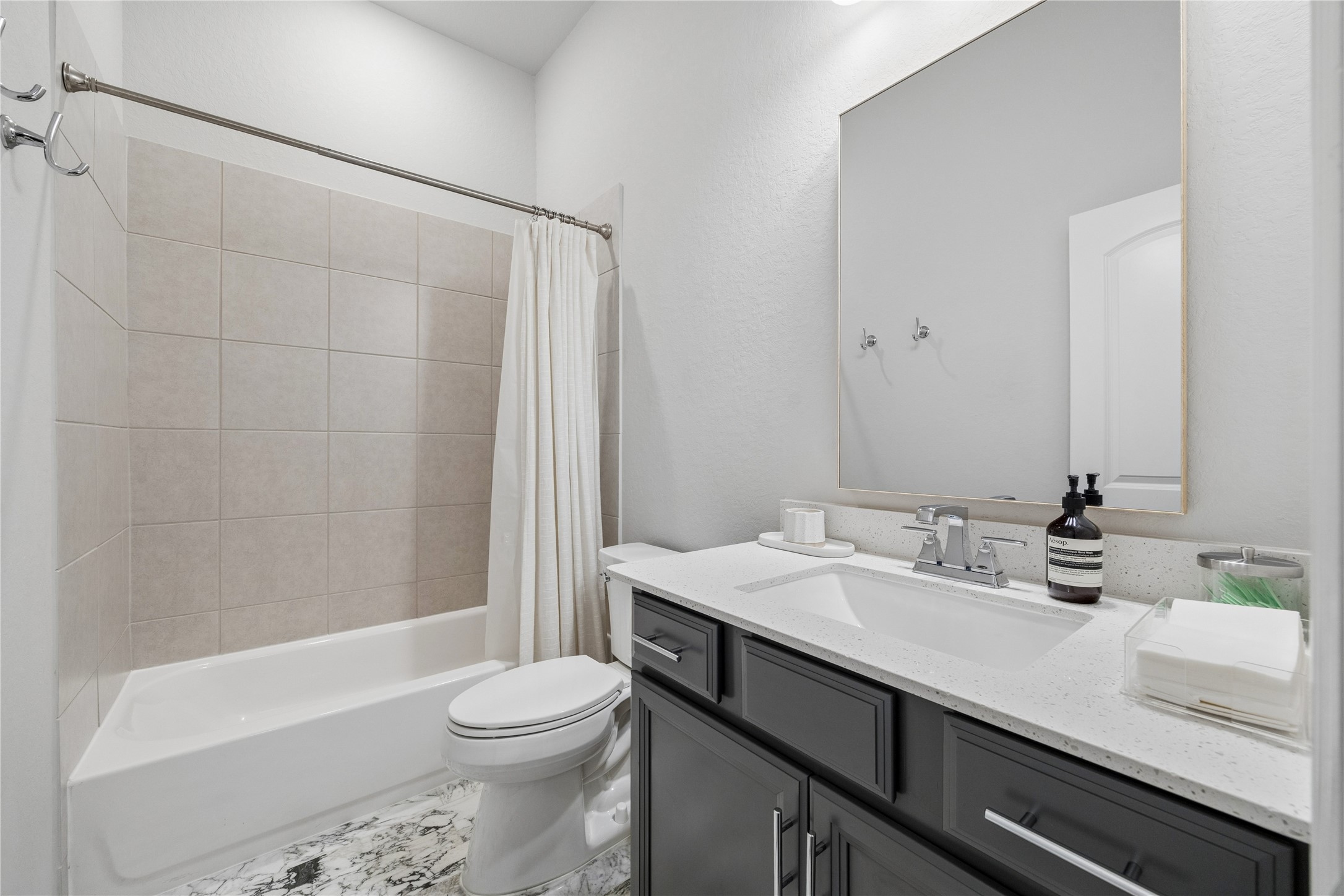 shared full bathroom near the 4th bedroom. updated marble floors and quartz countertops.