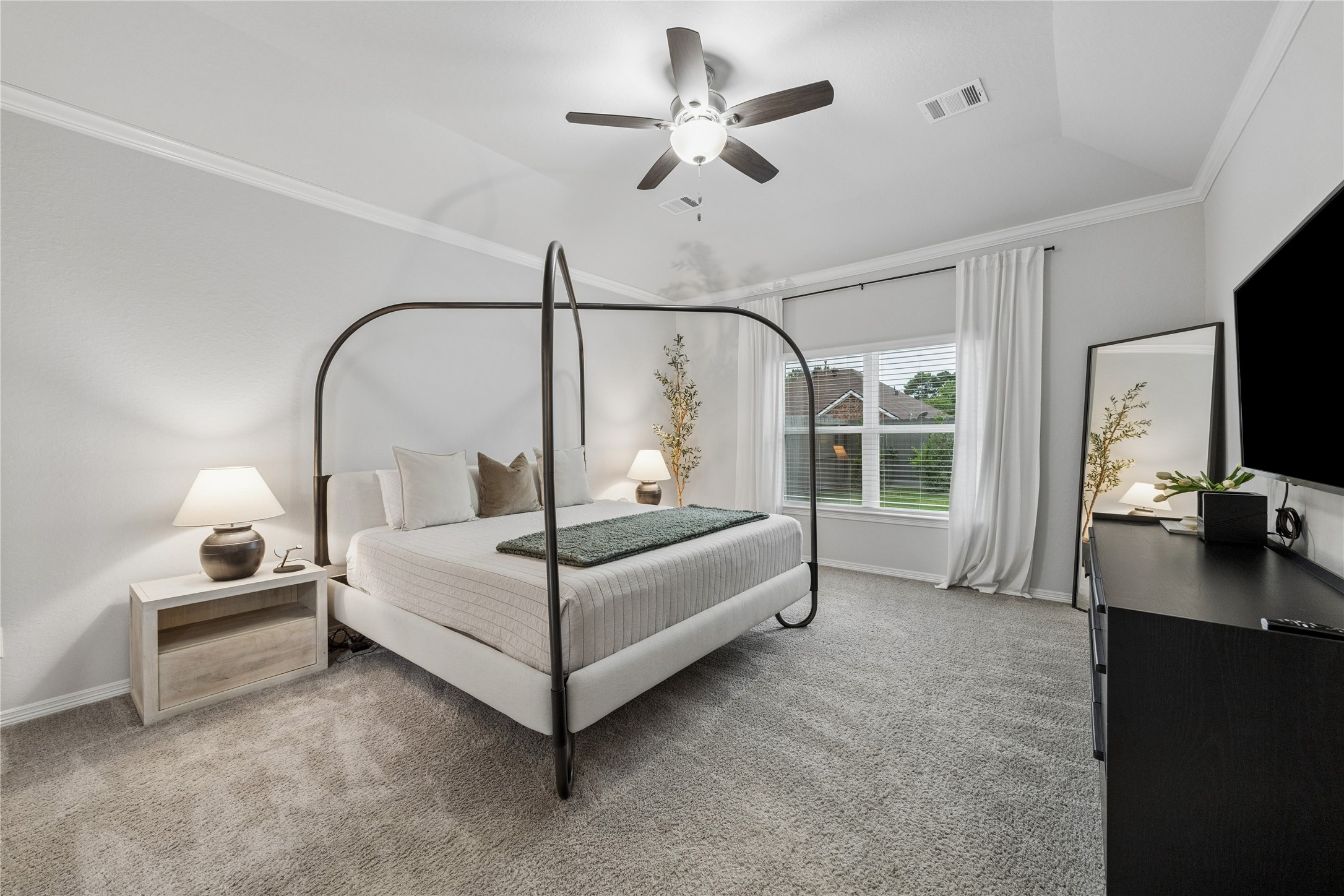 14x17 primary bedroom near the back of the house, tall slanted ceilings, window treatments.