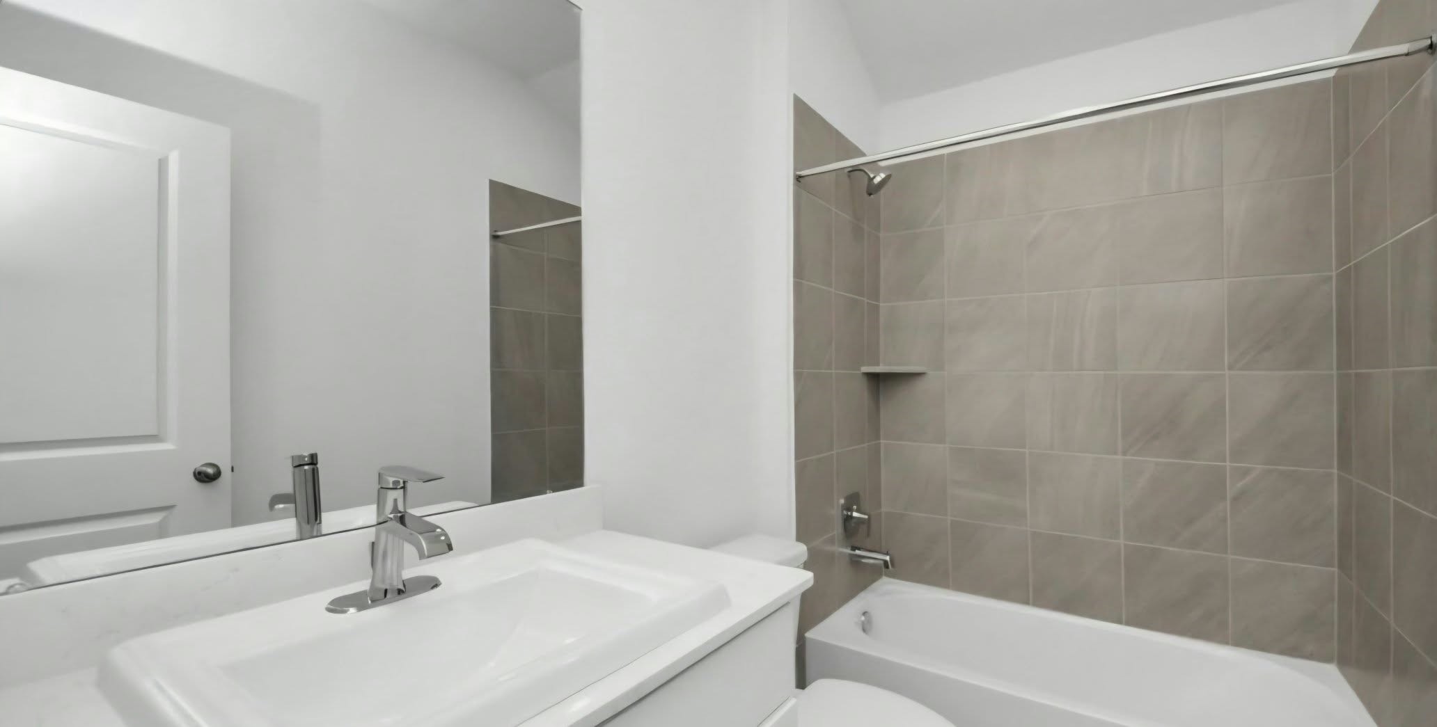 Full bathroom featuring a spacious vanity and tiled tub and shower combination.