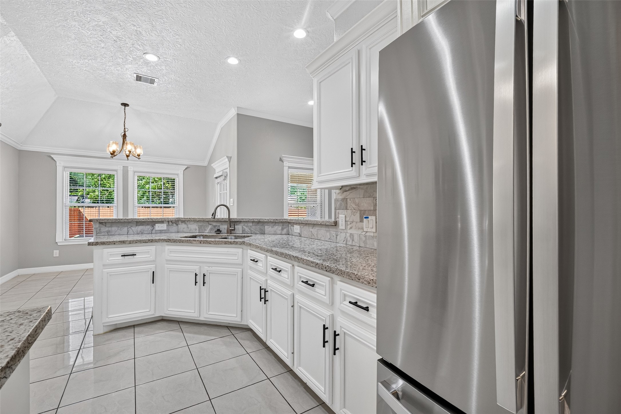 Elegant kitchen featuring sleek stainless steel appliances, refrigerator included.