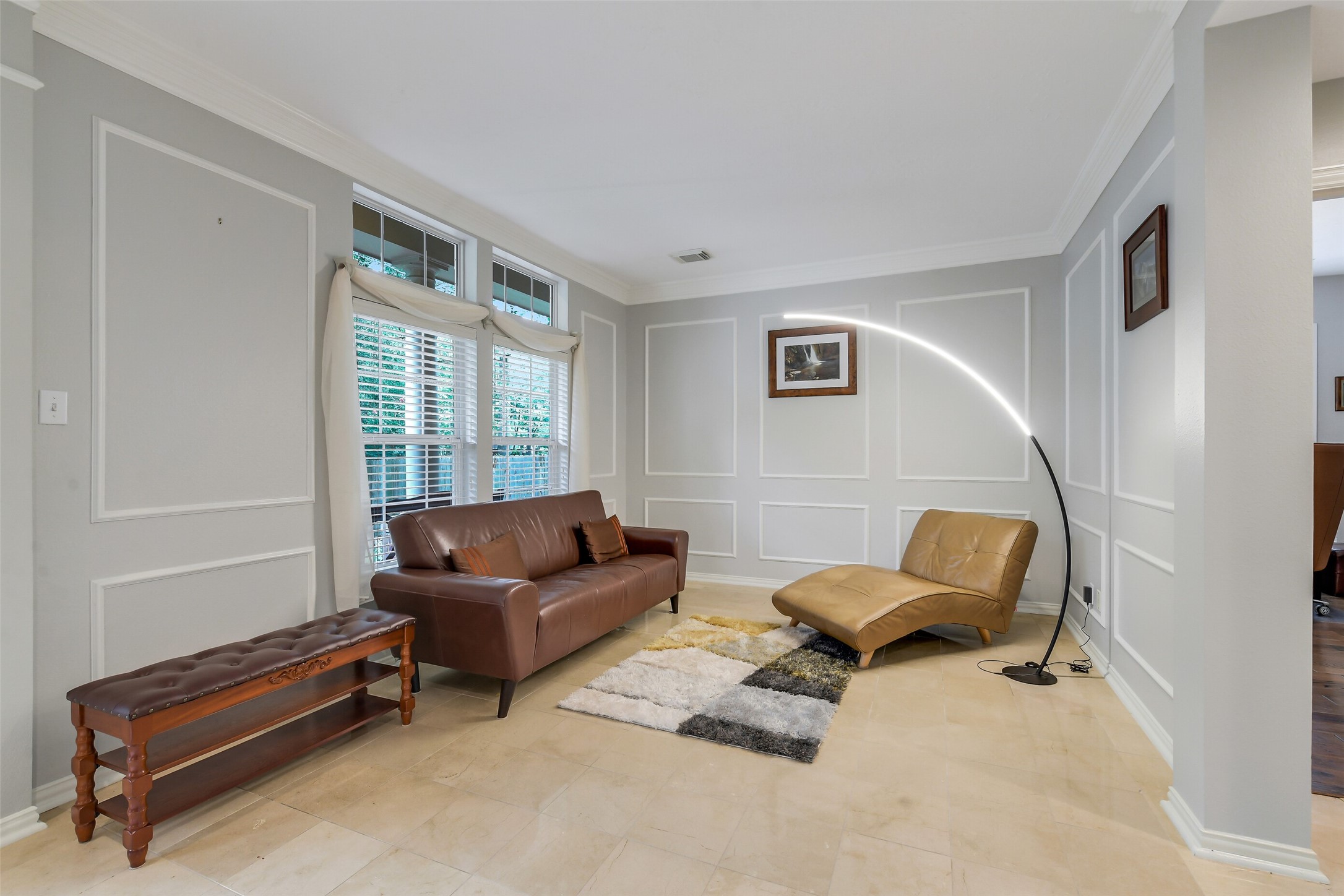 Elegant living room featuring a modern, complemented by large windows with abundant natural light.