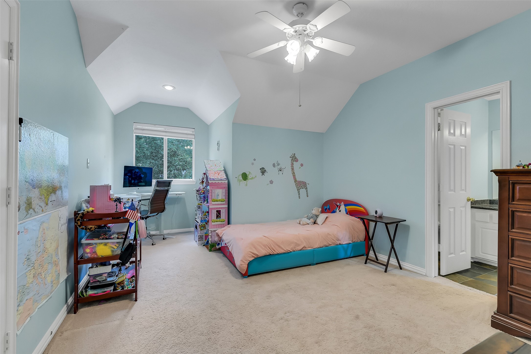 Spacious bedroom with soft blue walls, featuring a cozy bed, study area with desk, and a jack and jill . Perfect for creating a comfortable and personalized space.
