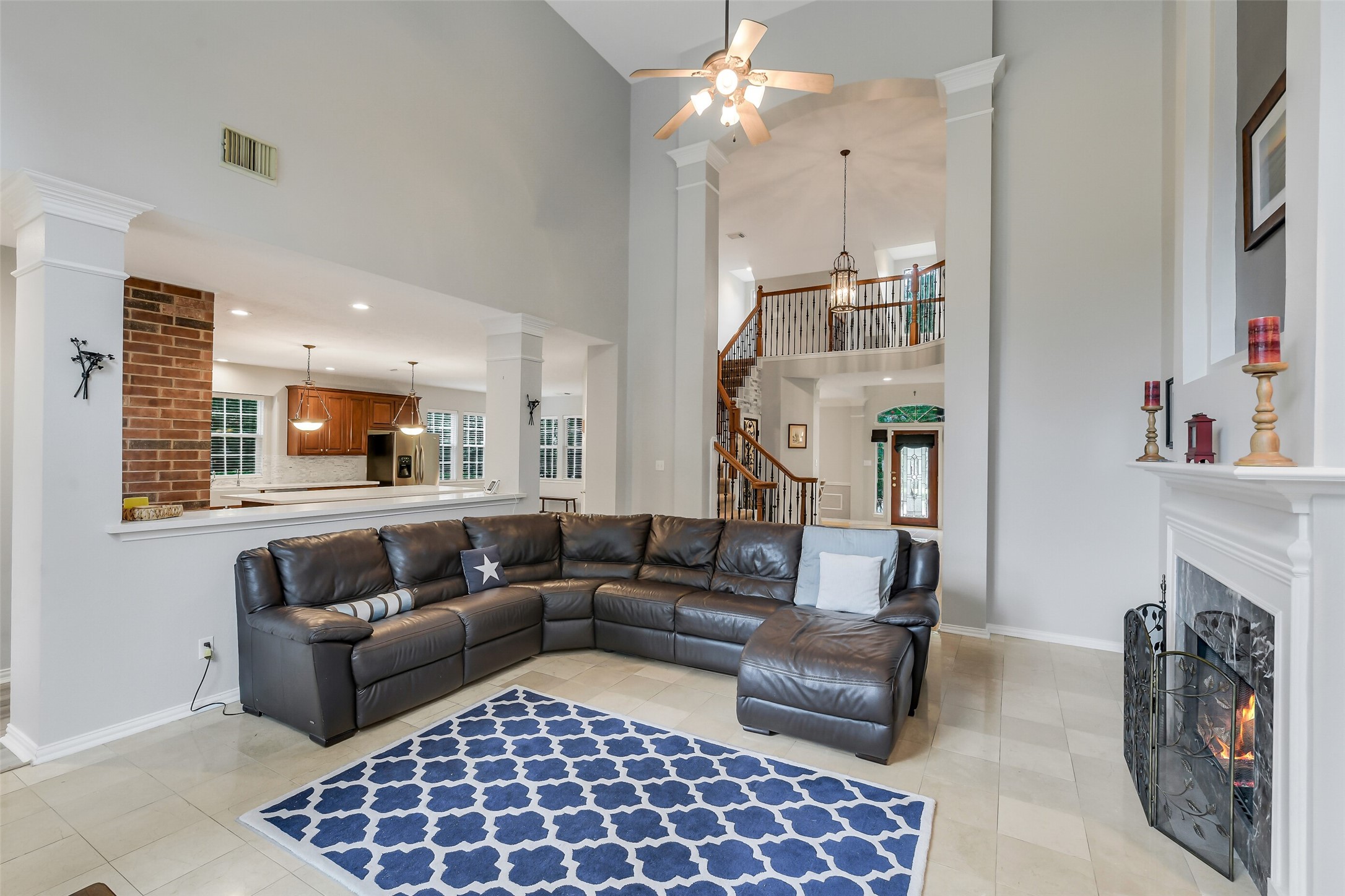 Spacious living room with vaulted ceilings, a cozy fireplace, and an open layout leading to a modern kitchen.
