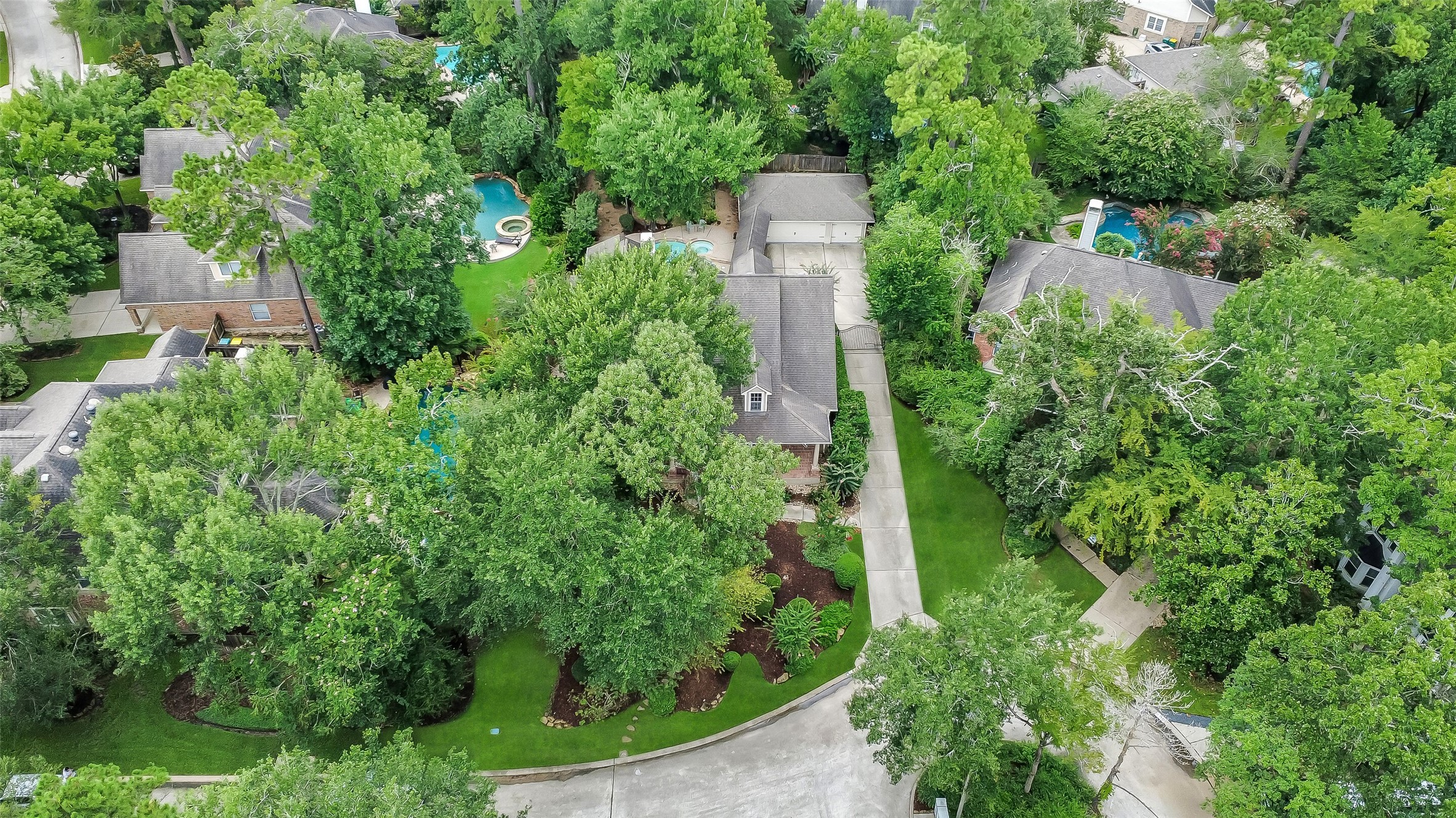 Nestled in a lush, green neighborhood, this charming home features a spacious driveway and is surrounded by mature trees, offering privacy and tranquility. The backyard includes a sparkling pool, perfect for relaxing or entertaining.