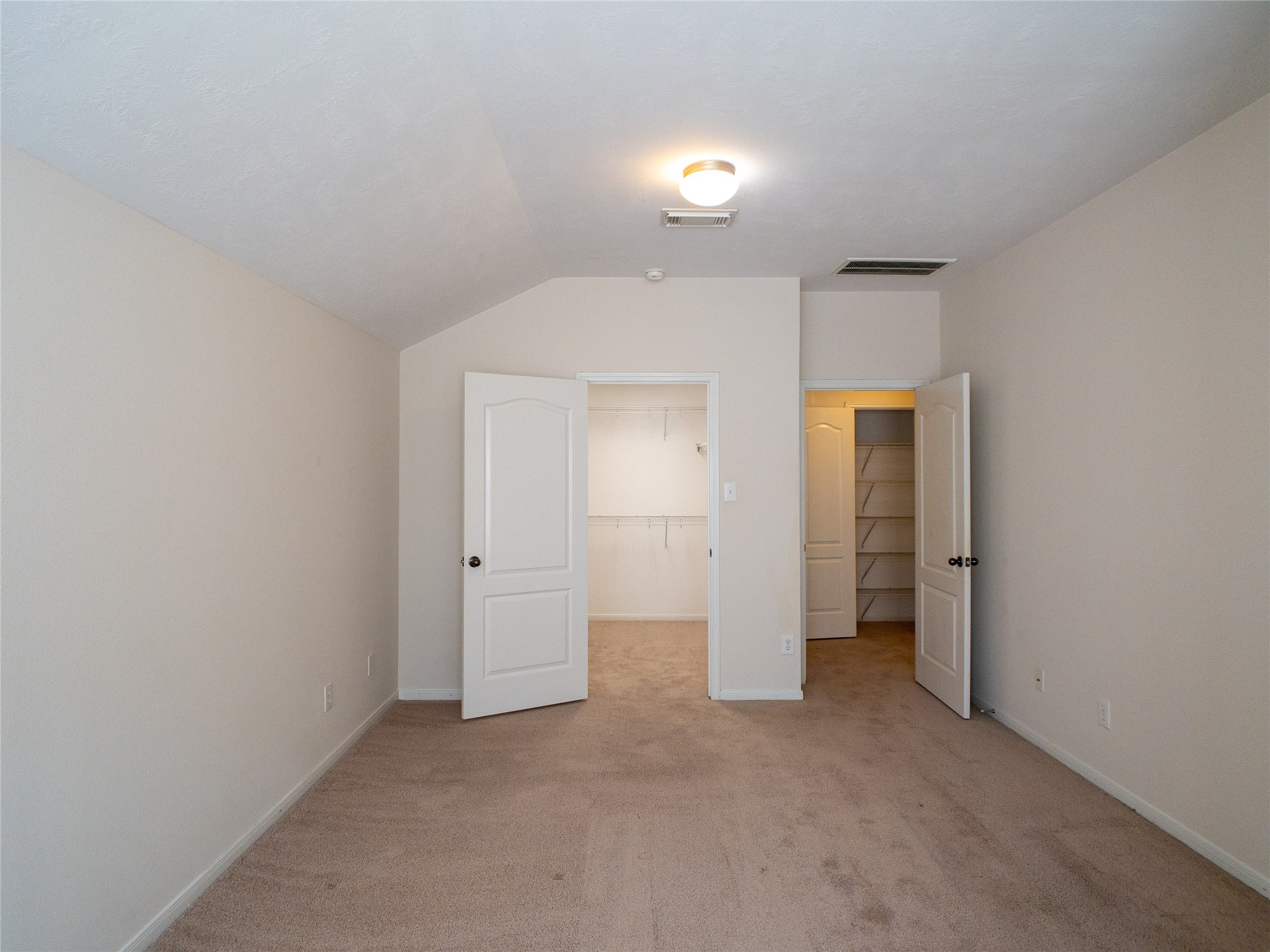 reverse view of primary bedroom with primary closet; 2nd-floor landing/linen closet can be seen through the door to the right