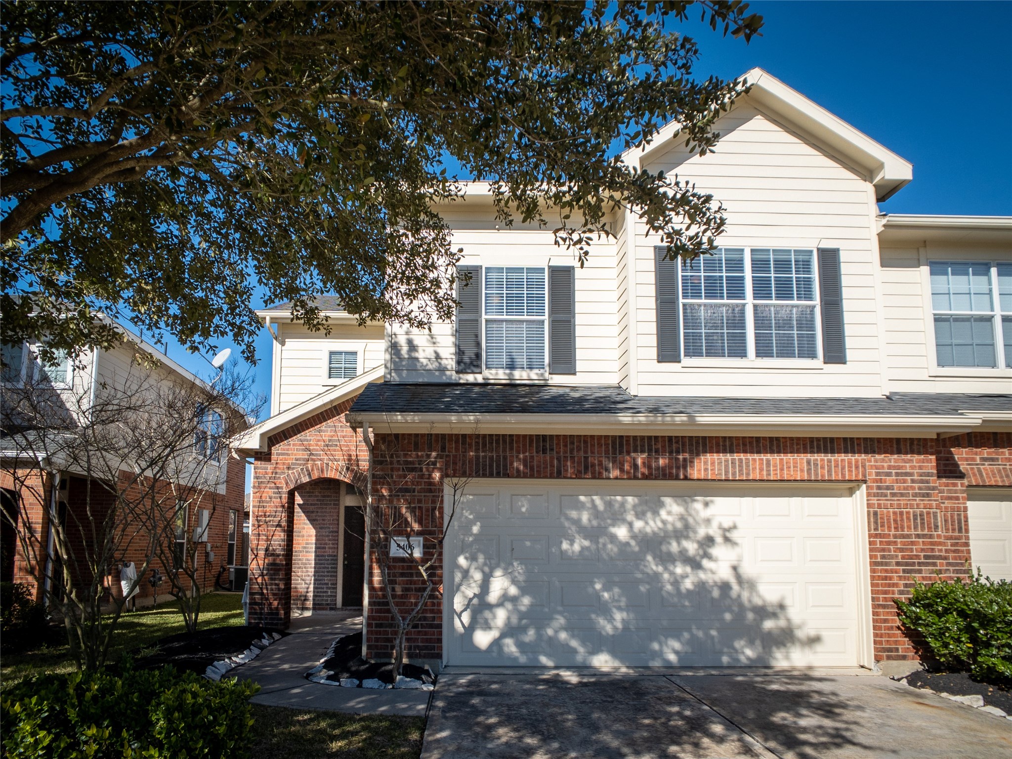 2-story duplex townhome with nice, red brick & mature tree