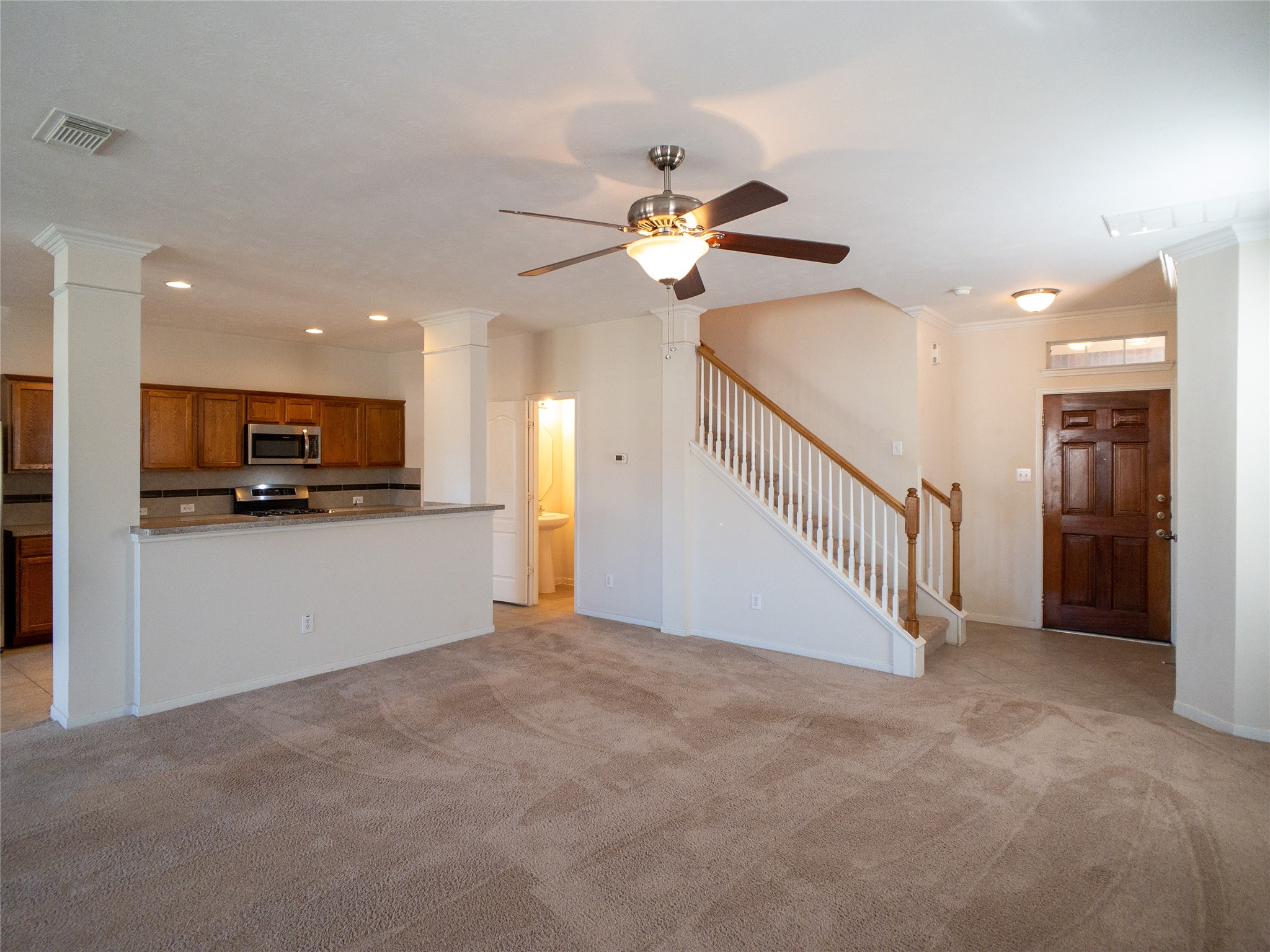 another view of living room with kitchen/breakfast bar and powder room