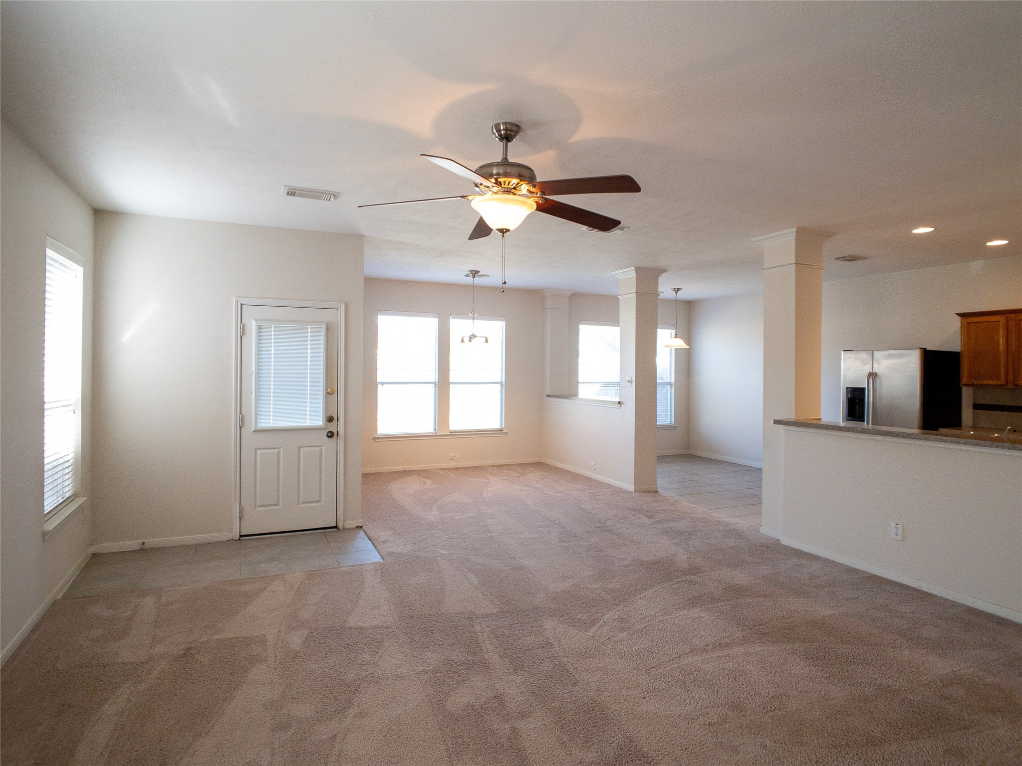 living room with dining room and breakfast beyond, door to back yard, and kitchen to the right