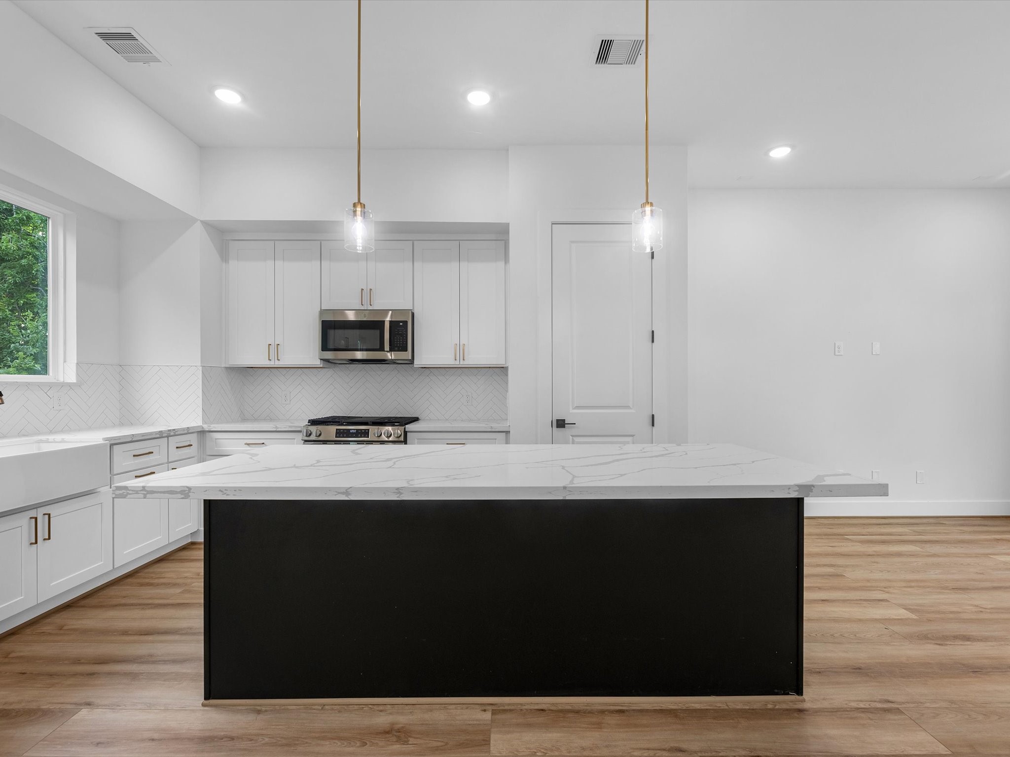 The kitchen is complete with a large farmhouse-style deep sink, adding both functionality and a beautiful modern touch to the space.