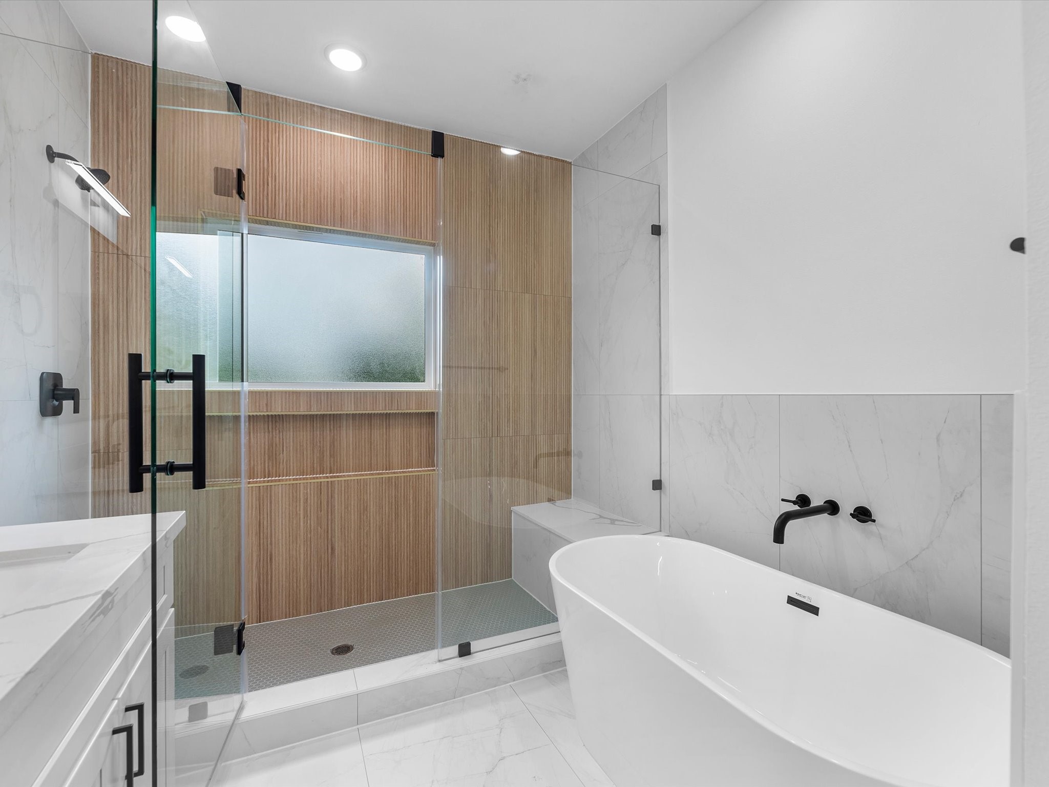 Luxurious bathroom featuring stylish accent walls in the shower and a sleek shower-tub combination. A designated vanity space adds extra functionality, while modern finishes and thoughtful details create a beautiful, spa-like feel.