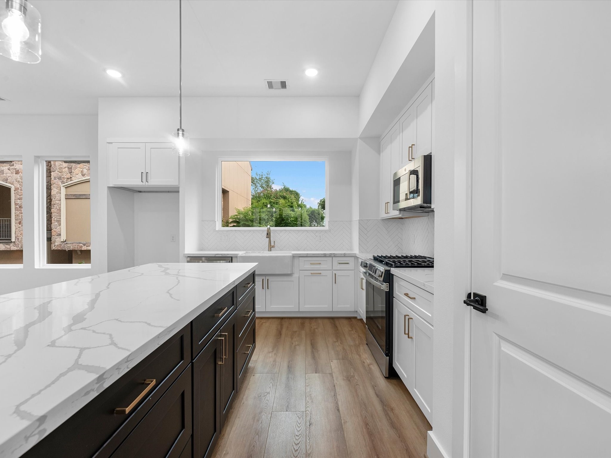The kitchen is complete with a large farmhouse-style deep sink, adding both functionality and a beautiful modern touch to the space.