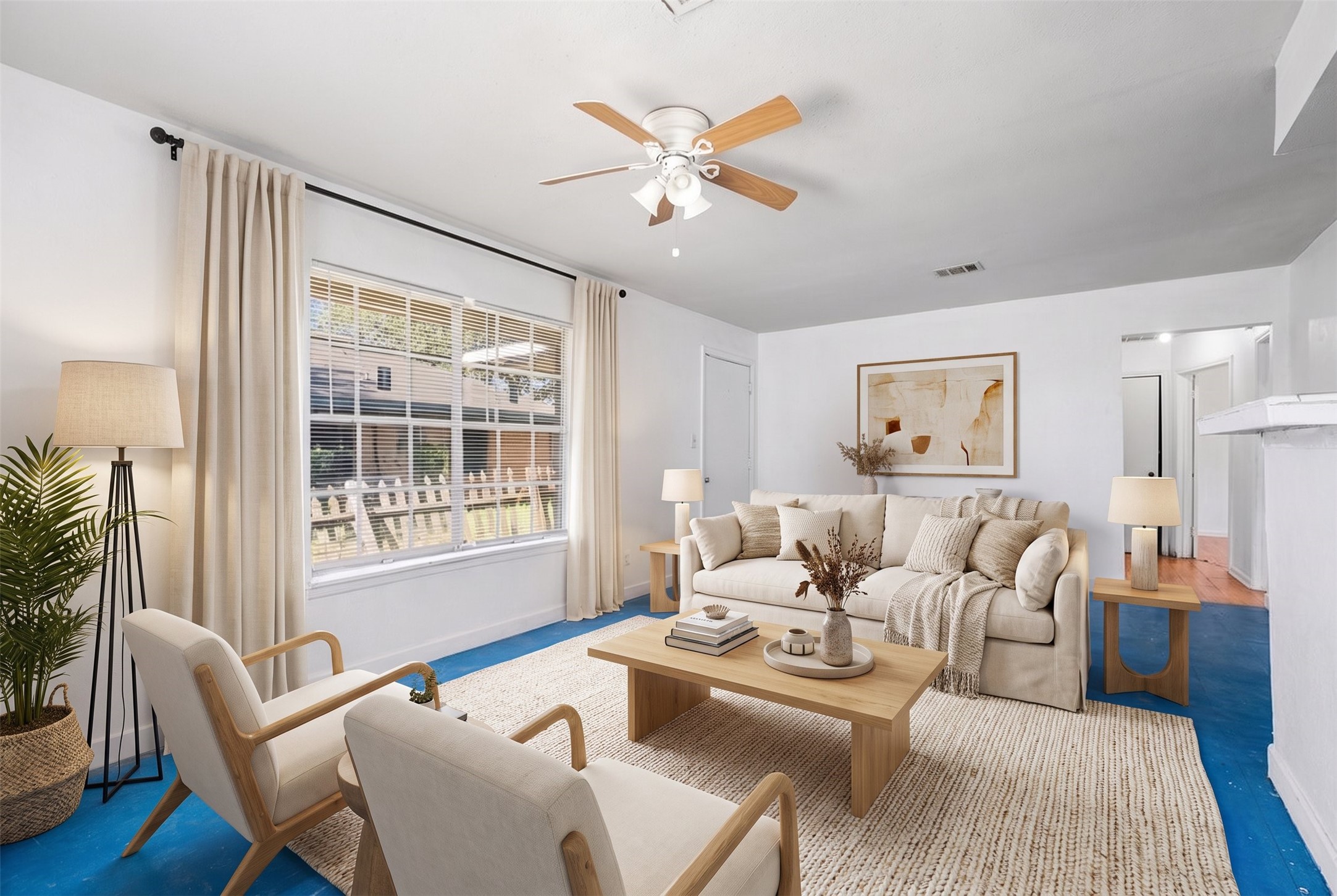 The living room boasts a ceiling fan, tile flooring and a large window that brightens the space. *Virtually Staged