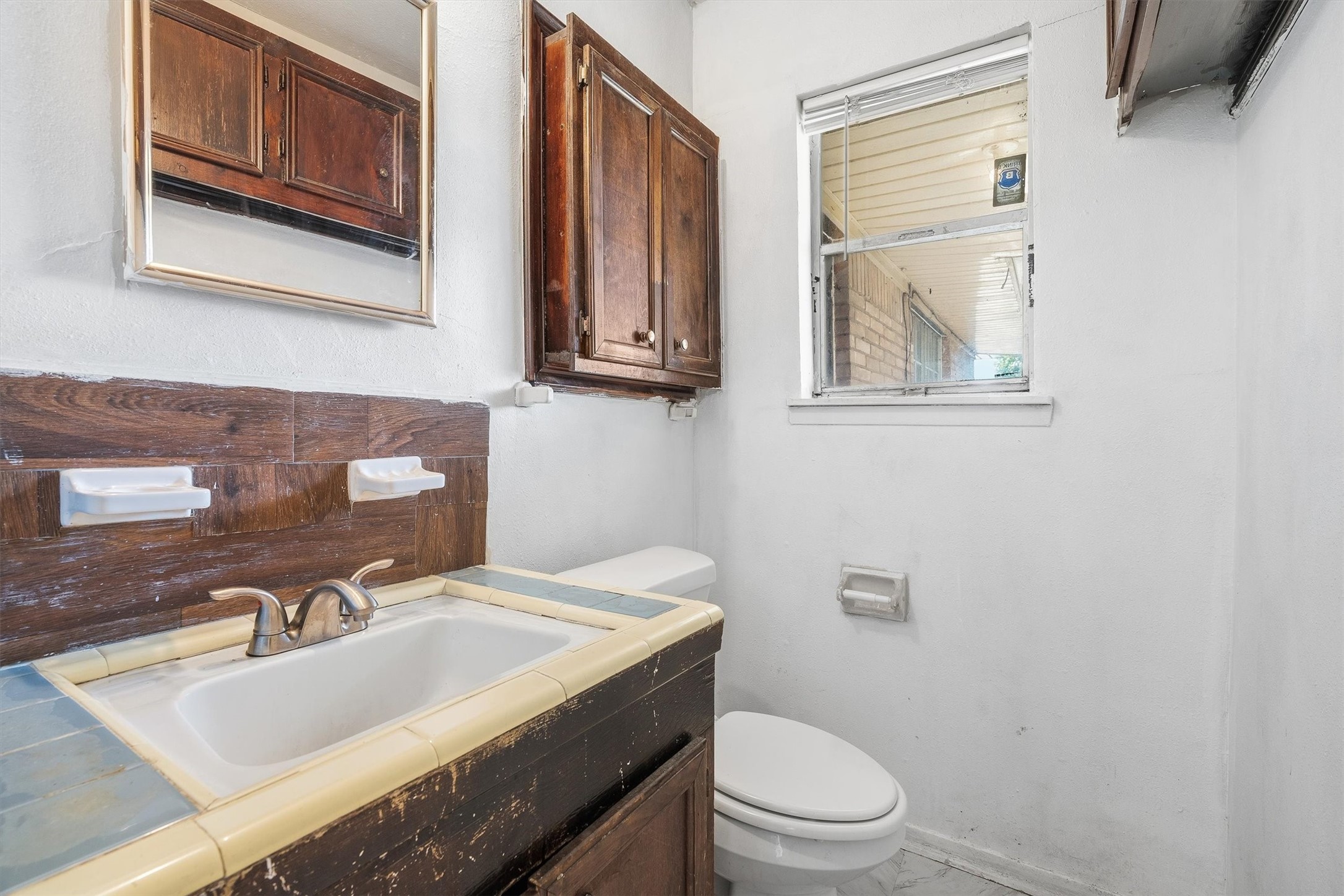 The convenient half bathroom features a toilet and single-sink vanity, offering a great opportunity to add your personal touch and create a refreshed space that suits your style!