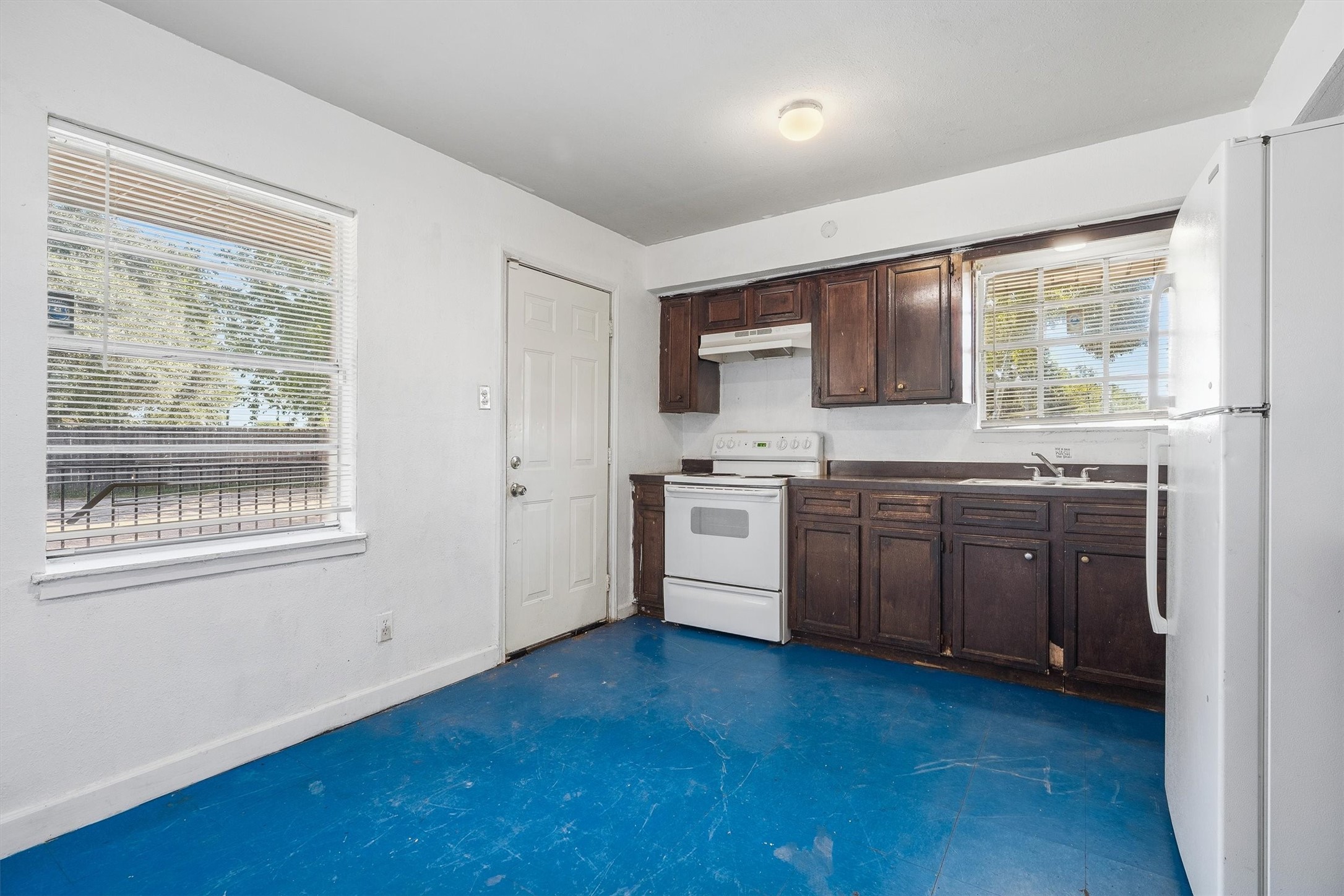 The kitchen also offers spacious windows with privacy blinds, along with direct access to the backyard  perfect for effortless indoor-outdoor entertaining.
