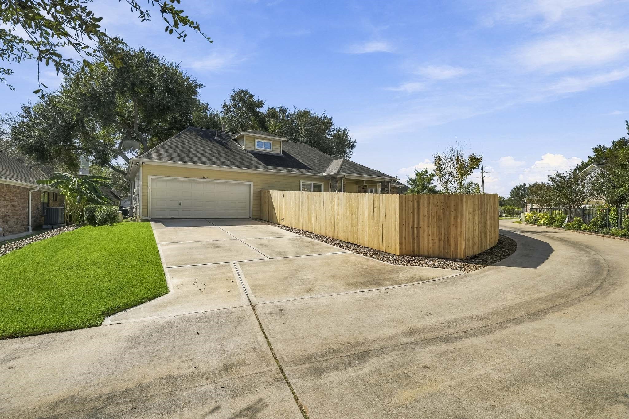 Tucked away from the street, a private drive leads to the home's driveway and 2-car Garage, offering both convenience and a heightened sense of privacy. A decorative rock-lined perimeter traces the fence line, adding a polished finishing touch to the landscape while supporting proper drainage and low-maintenance outdoor living.