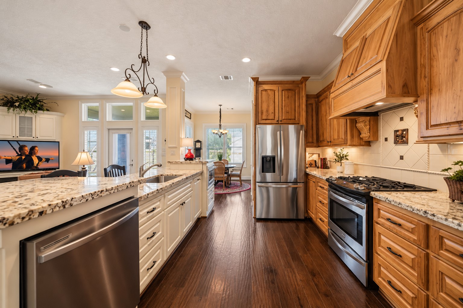 The home chef is sure to be inspired by this stunning Kitchen, where timeless design meets everyday functionality. Rich natural wood cabinetry is beautifully complemented by a contrasting white Island, while high-end granite countertops, a decorative tile backsplash, crown molding, and recessed lighting add layers of elegance and visual interest.