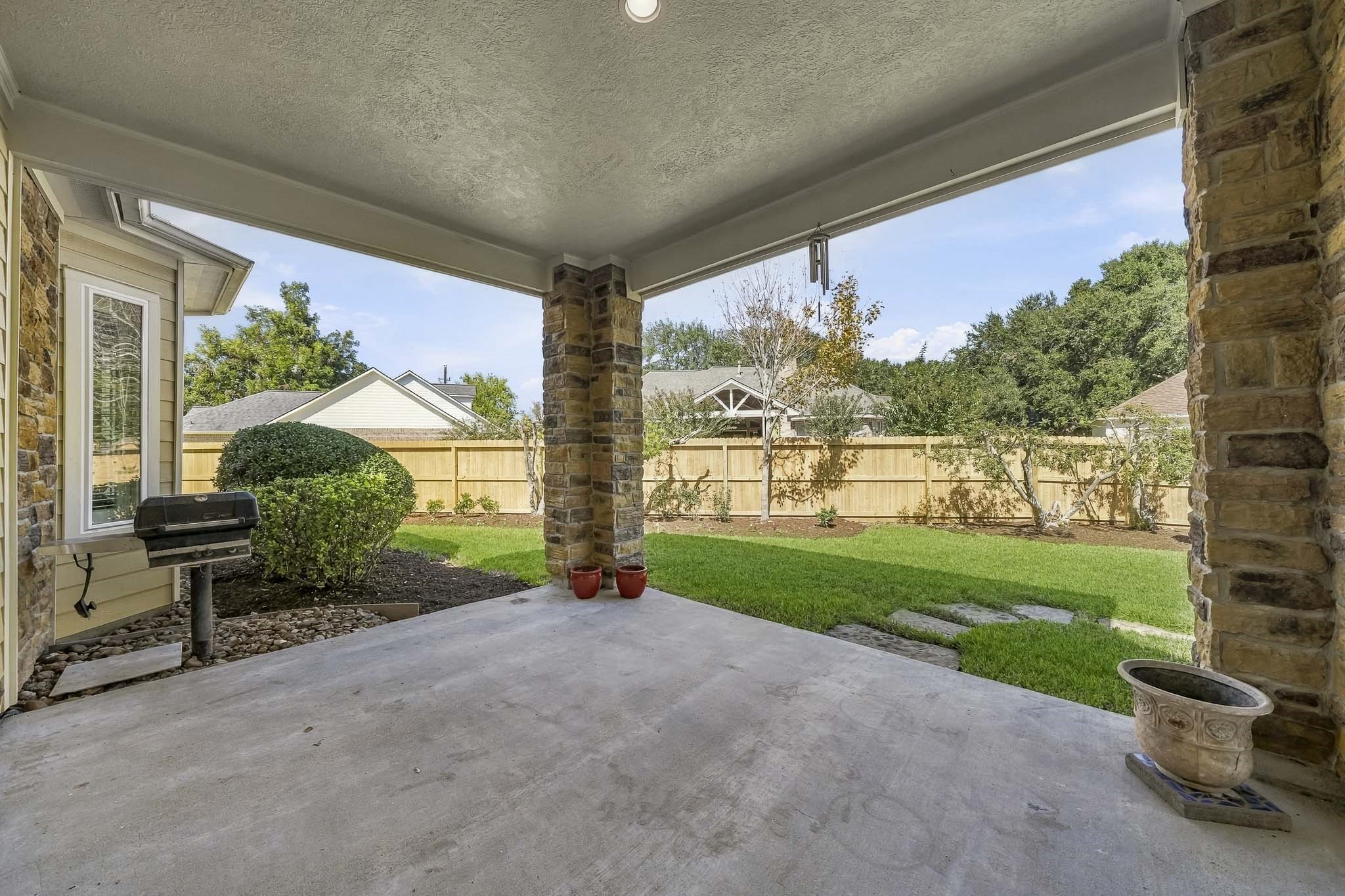 This covered Back Patio creates the perfect outdoor retreat, thoughtfully appointed with a built-in gas grill, stacked stone pillars, and recessed lighting for effortless day-to-night enjoyment. Surrounded by an abundance of privacy, the space offers an inviting setting for everything from casual family dinners to memorable gatherings with friends.