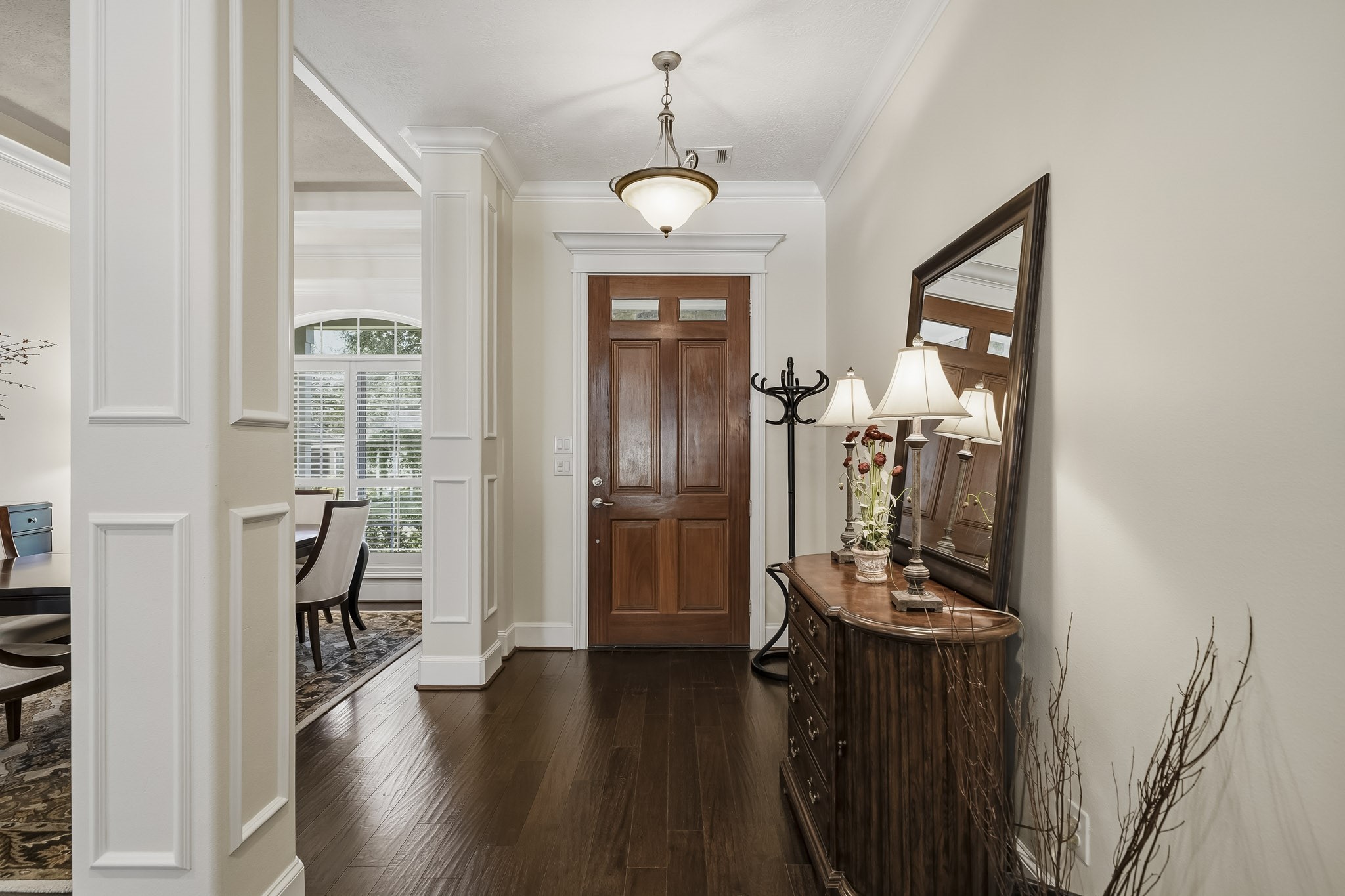 This look back showcases the spacious and airy Foyer, where crown molding, elegantly cased pillars, and a solid wood Front Door create a warm yet sophisticated first impression. Generous in size and thoughtfully designed, the space offers ample room for a bench, coat rack, console, or additional storage piece, blending beauty with everyday functionality. This look back showcases the spacious and airy Foyer, where crown molding, elegantly cased pillars, and a solid wood Front Door create a warm yet sophisticated first impression. Generous in size and thoughtfully designed, the space offers ample room for a bench, coat rack, console, or additional storage piece, blending beauty with everyday functionality.