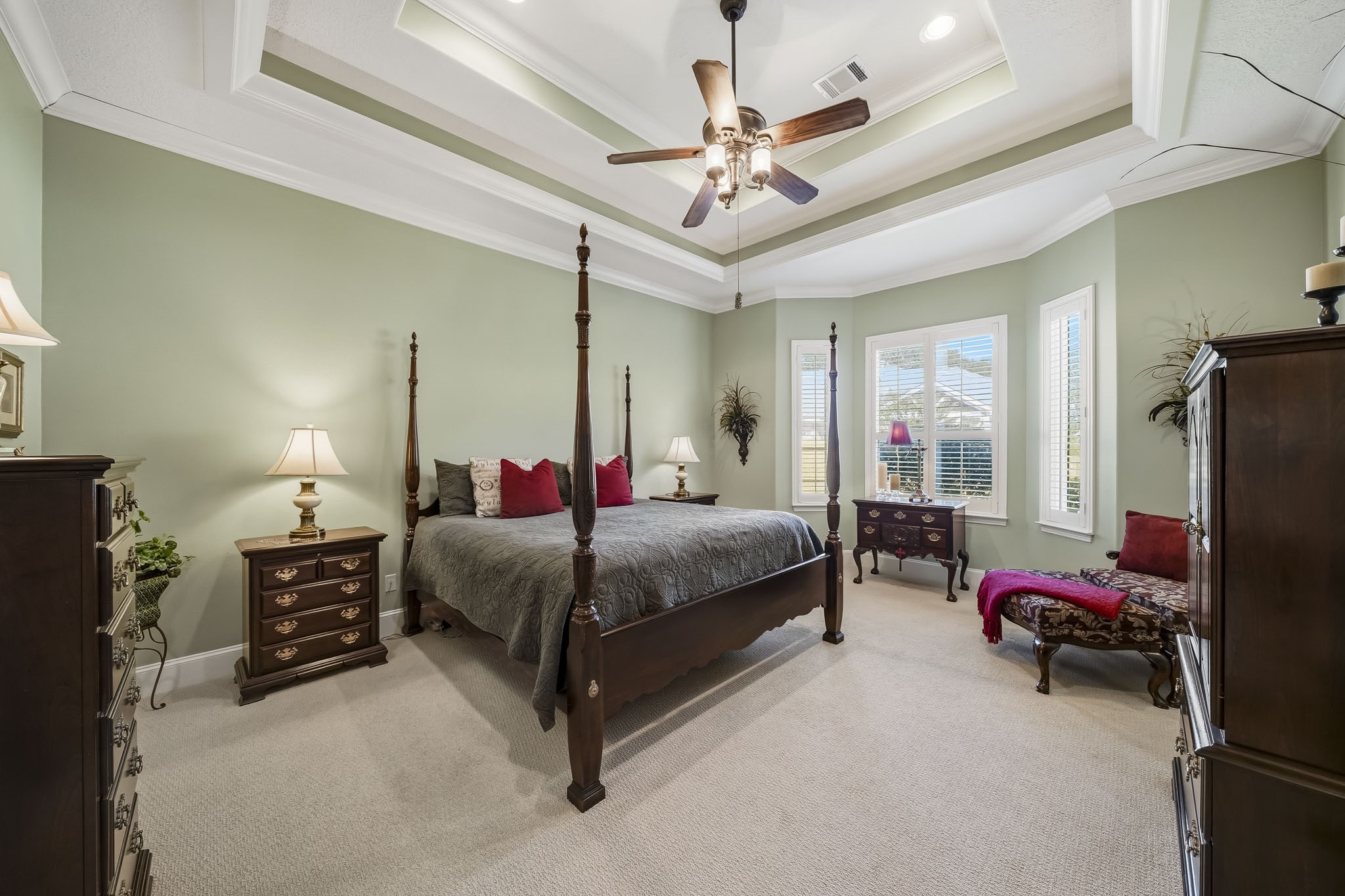 Rest and recharge in the comfort of this spacious Primary Bedroom, a serene retreat designed for both relaxation and everyday living. Natural light pours through a trio of windows adorned with plantation shutters, creating a bright yet tranquil atmosphere. Generous proportions easily accommodate a king-sized bed, dual nightstands, and a dresser, while still leaving ample room for a cozy sitting area, reading nook, or dedicated workspace.