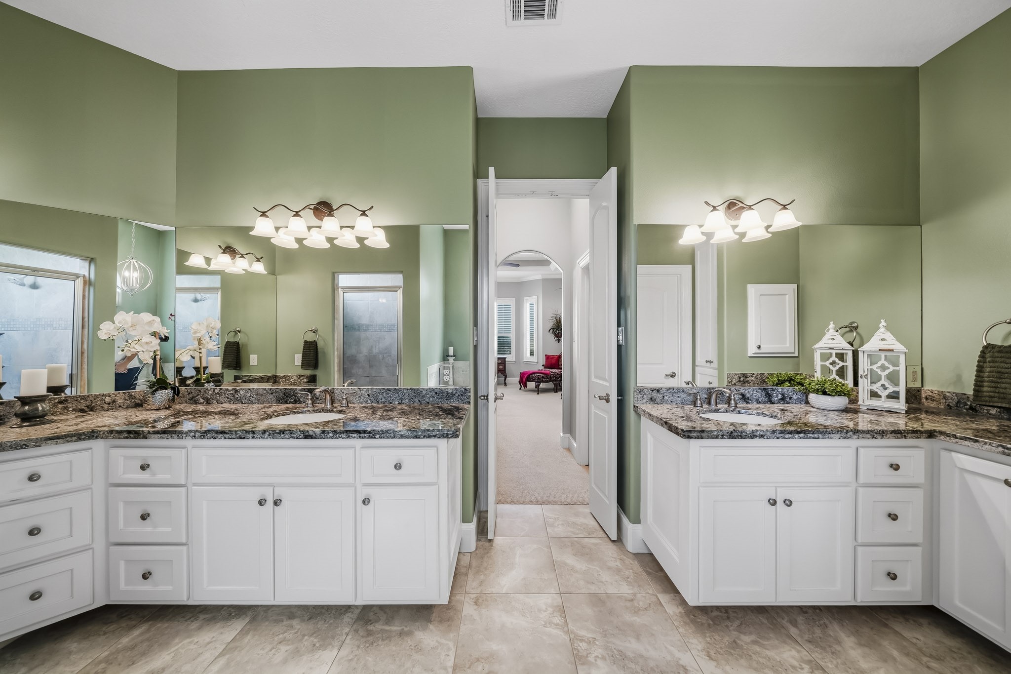 Thoughtfully designed for comfort and functionality, the dual vanities are beautifully finished with premium granite countertops, undermount sinks, extensive cabinetry, and a dedicated makeup vanity. Just beyond, a private hallway seamlessly connects the Primary Bedroom and Bathroom, where separate doors reveal expansive his & her walk-in closets, offering a boutique-inspired dressing experience and exceptional storage.