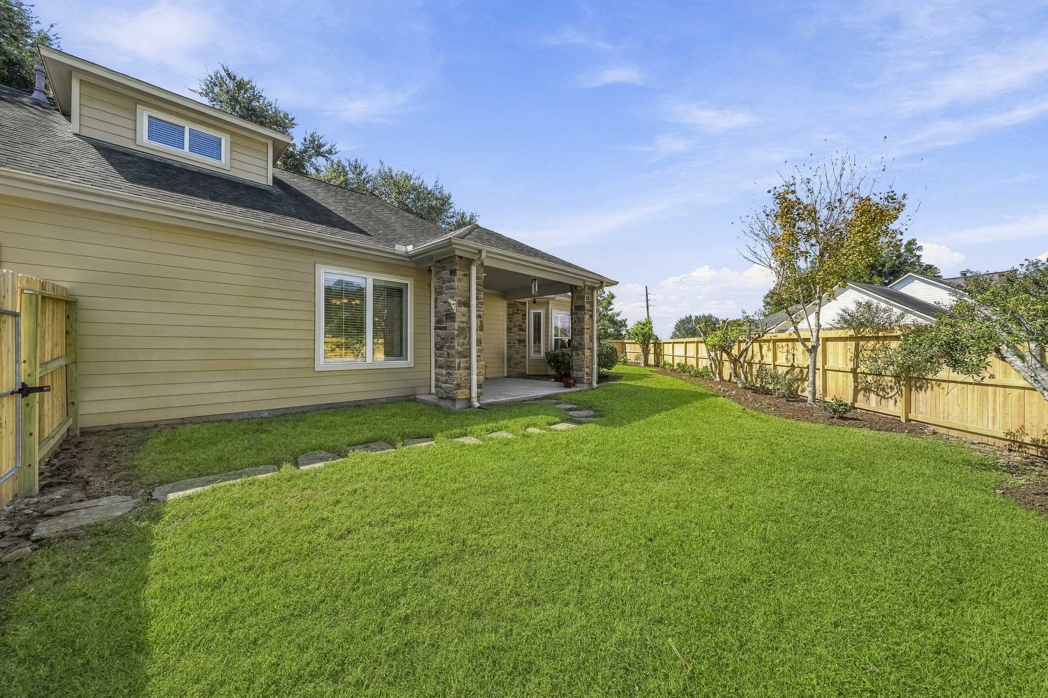 The Backyard offers a lush, green expanse that serves as a peaceful extension of the home's outdoor living space. A thoughtfully planted row of trees and shrubs is poised to mature into a beautiful natural privacy screen, providing additional shade, enhanced seclusion, and a serene backdrop for years to come.